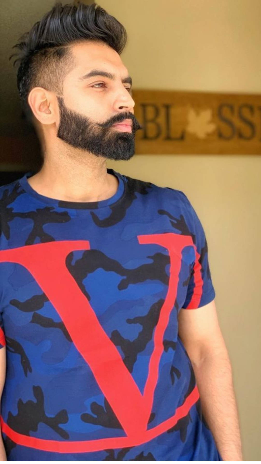 Indian 桌布 壁紙 — 一位留著時尚鬍鬚和刺蝟頭髮的男子，室內穿著一件帶有醒目紅色「V」標誌的藍色迷彩T恤。