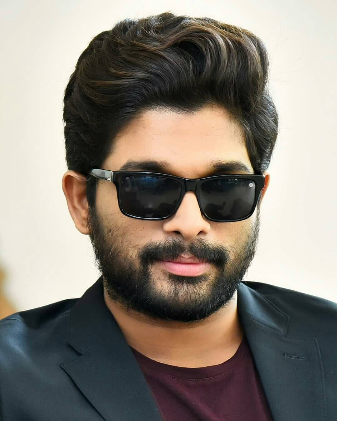 Allu Arjun 桌布 壁紙 — 一位留著時尚黑髮和鬍鬚的男人，戴著黑色太陽眼鏡，身穿黑色西裝外套，內搭栗色襯衫。