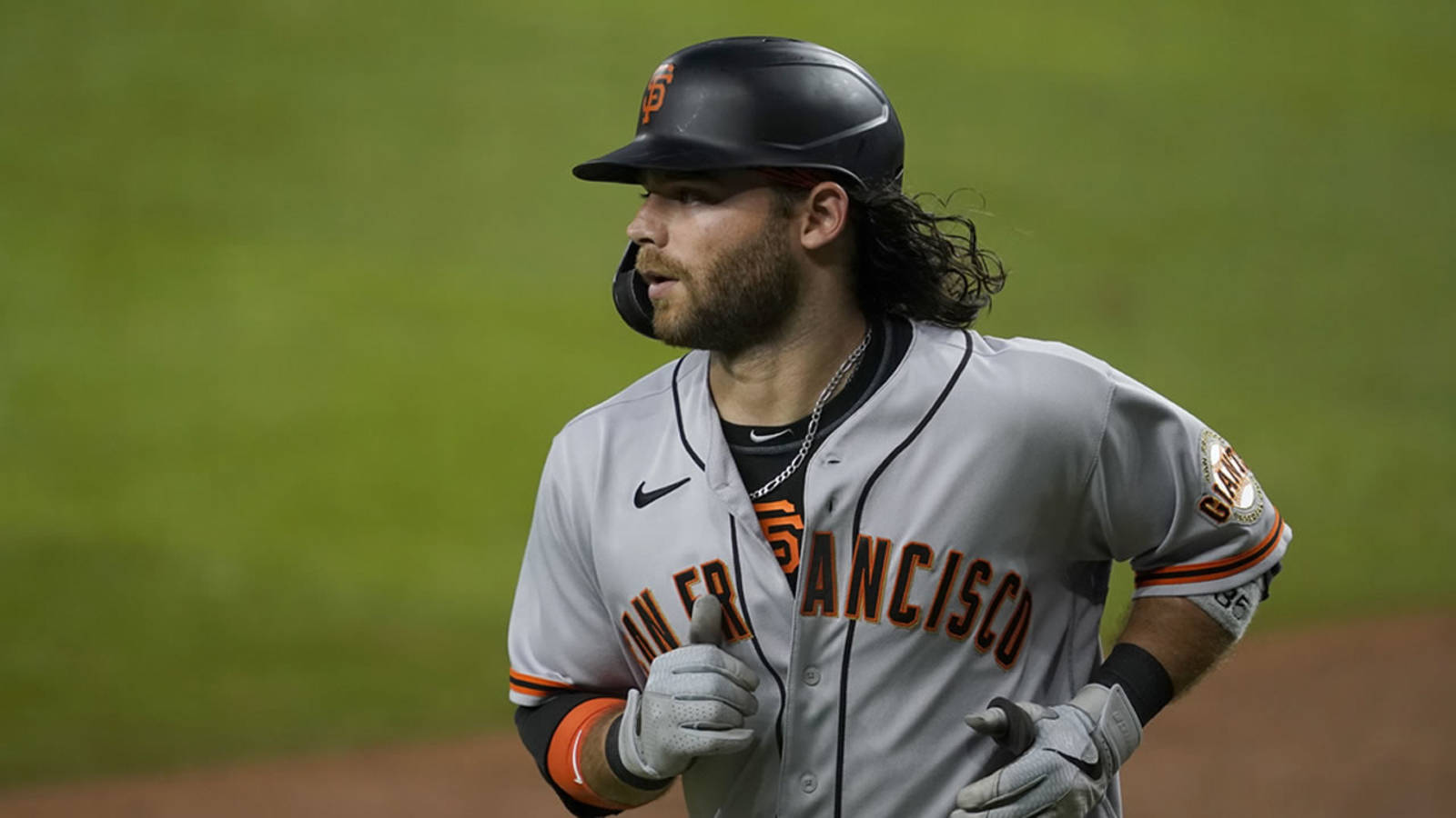 San Francisco Giants 桌布 壁紙 — 一位留著深色長髮的舊金山巨人隊棒球選手在球場燈光下奔跑。