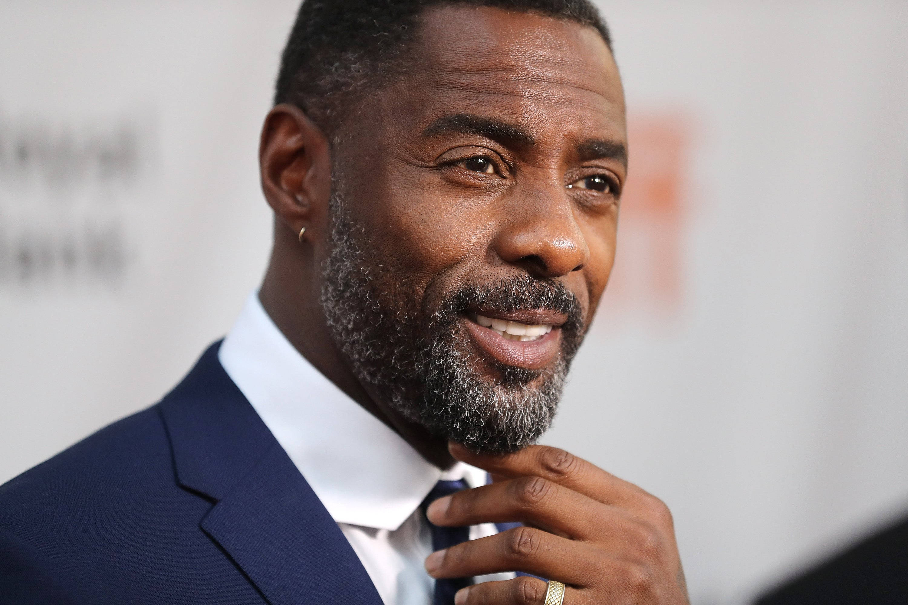 Celebrity 桌布 壁紙 — 一位留著灰色鬍鬚的微笑男士在正式活動中調整領帶的特寫。