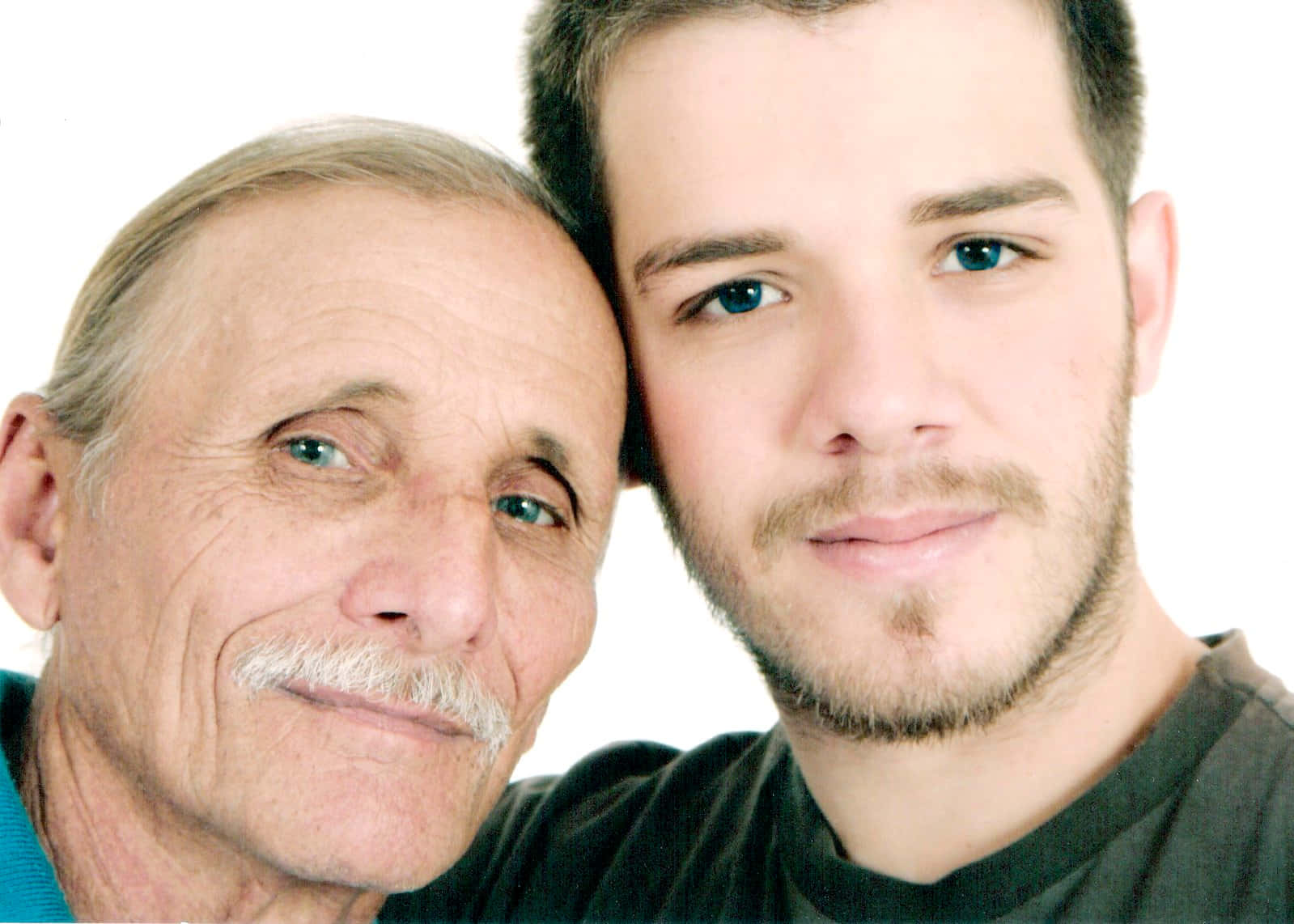 Father And Son 桌布 壁紙 — 一位留著白色鬍鬚的長者和一位藍眼睛的年輕男子在純白背景前緊密地擺姿勢。