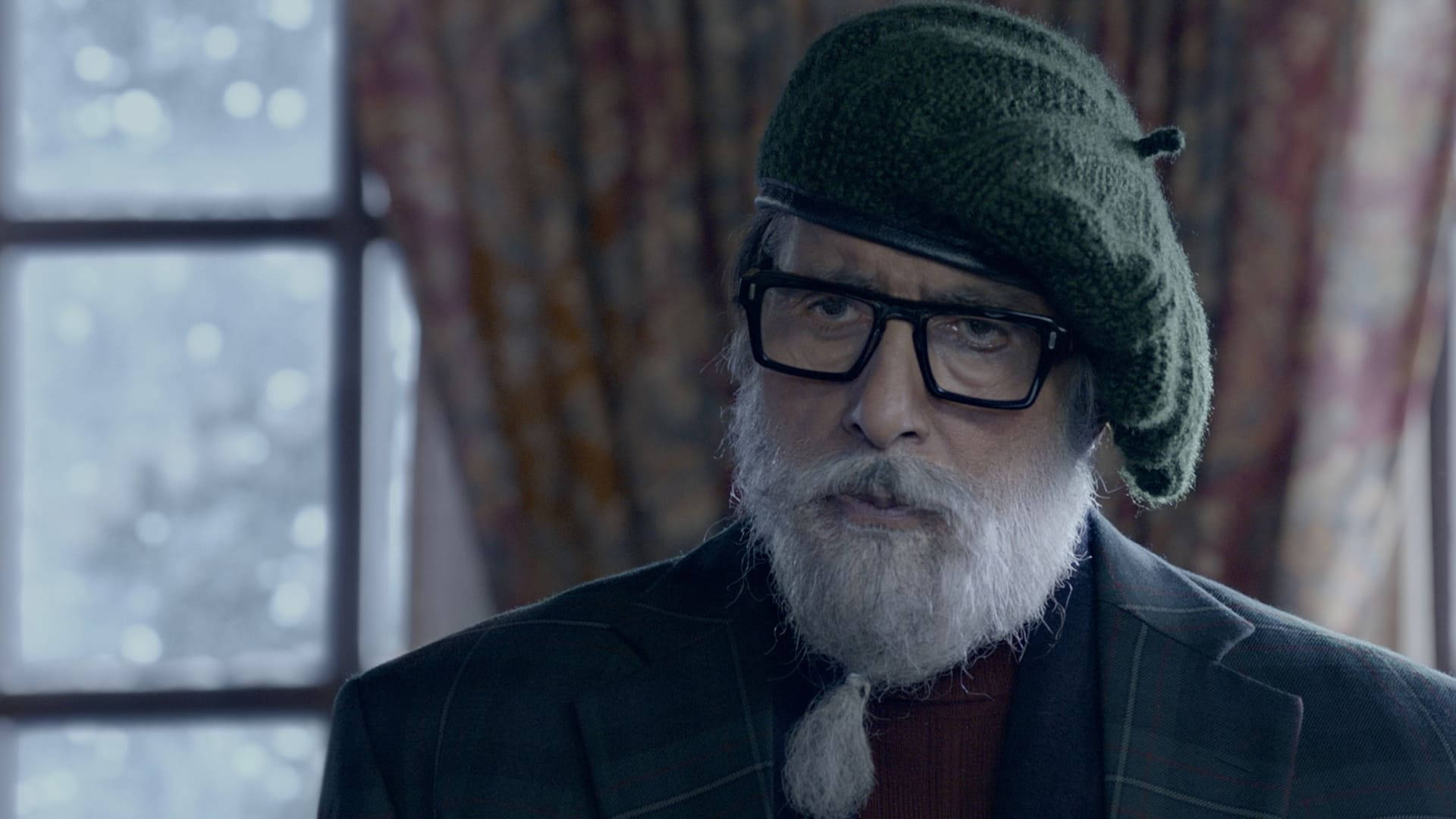 Amitabh Bachchan 桌布 壁紙 — 一位留著白鬍子、戴著綠色針織帽的老人，透過窗戶凝視著外面可見的雪花。