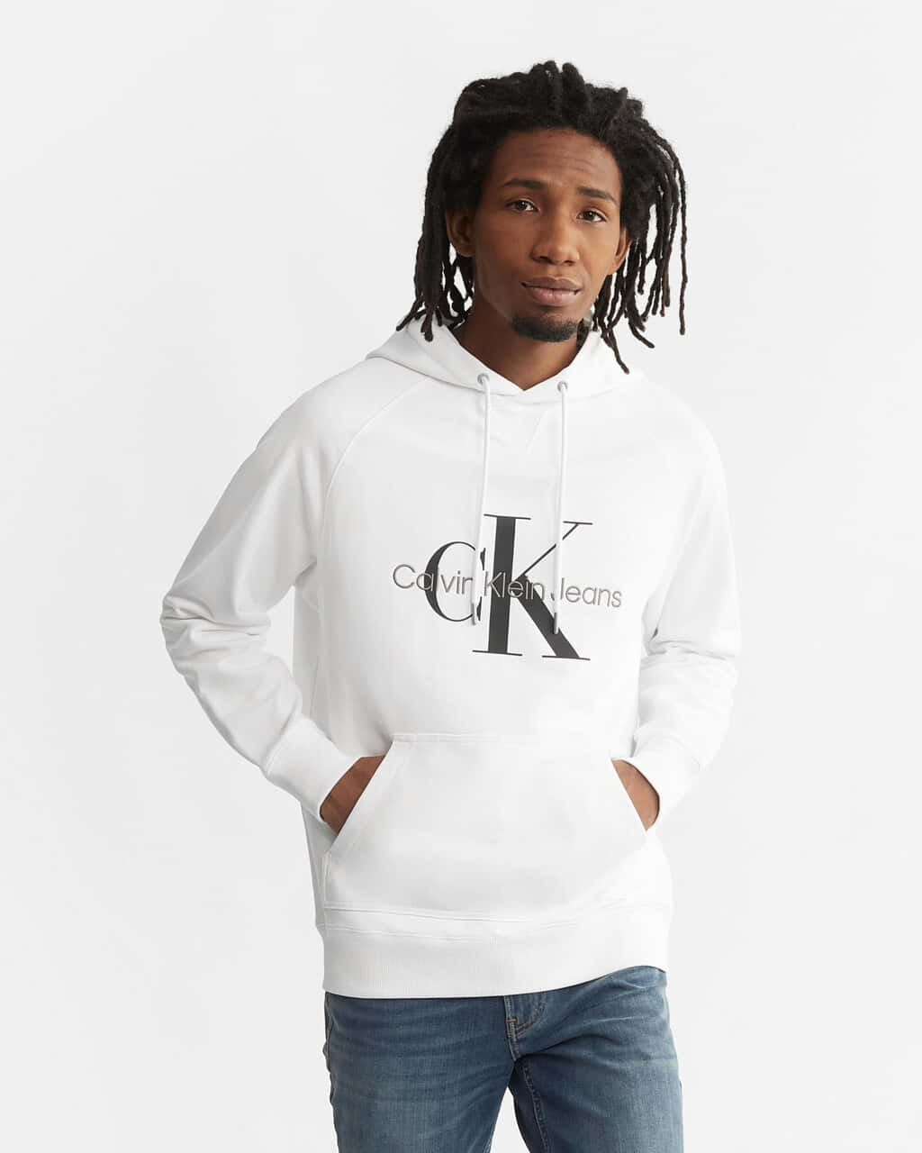 卡文克萊 桌布 壁紙 — 一位留著辮子的年輕男子，身穿白色Calvin Klein連帽衫和牛仔褲，背景為純白色。