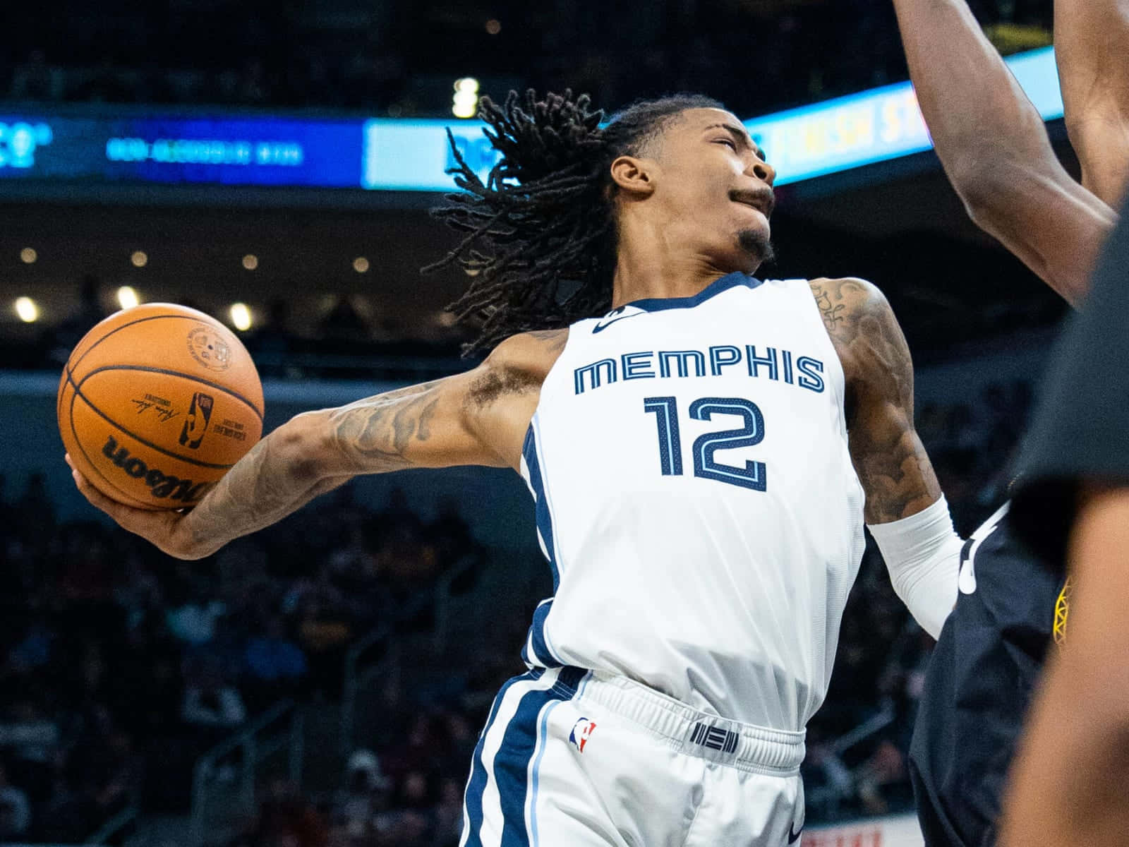 Ja Morant 動圖 桌布 壁紙 — 一位留著辮子的曼菲斯灰熊隊球員跳起投籃，而防守球員舉起手臂試圖封阻。