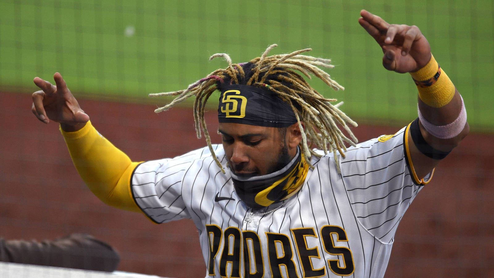 Tatis 桌布 壁紙 — 一位留著辮子的聖地牙哥教士隊棒球選手，穿著細條紋制服在綠色球場上慶祝。