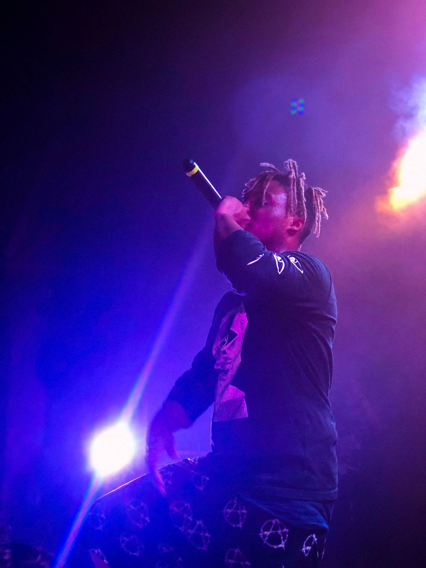 饒舌歌手在彩色燈光和煙霧效果下於舞台上表演。 — Juice Wrld 壁紙