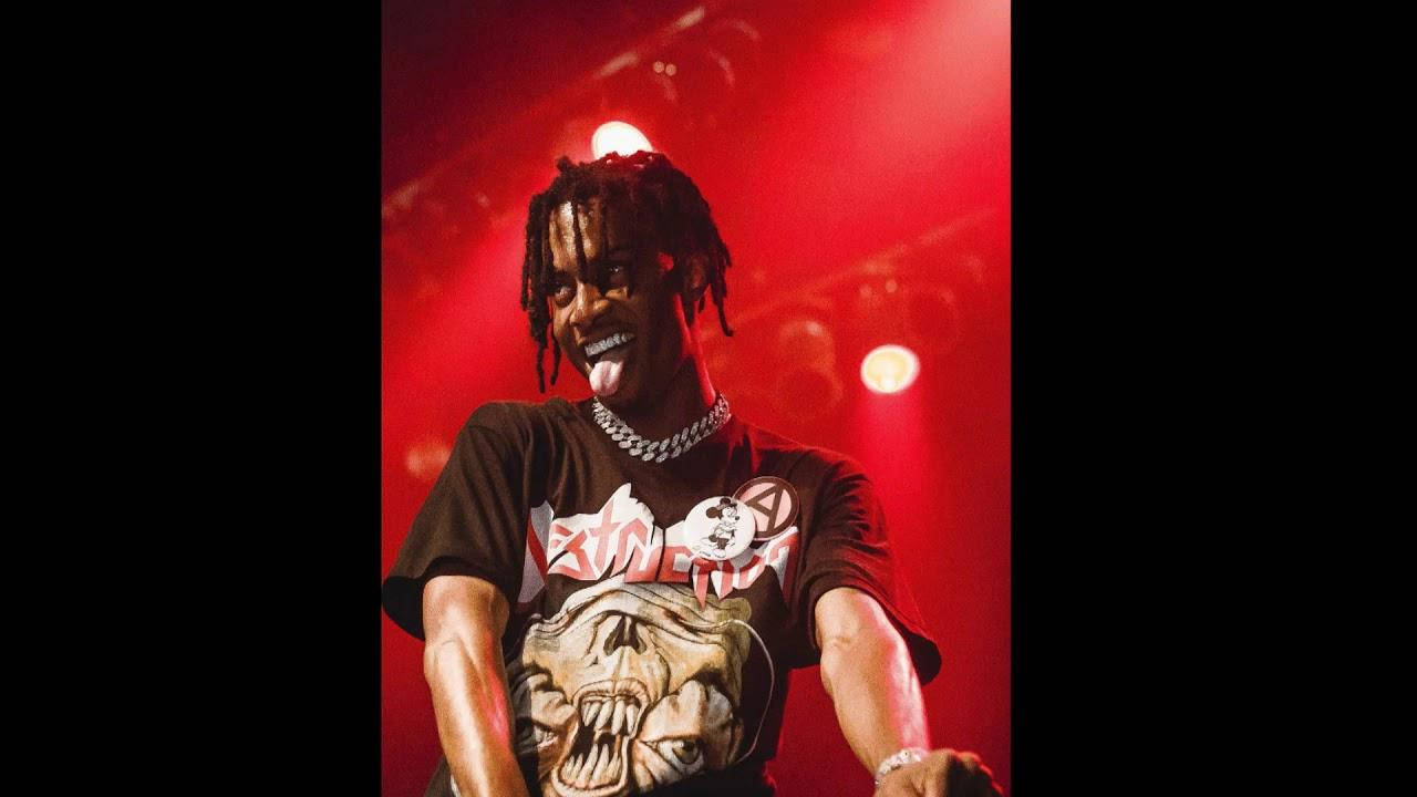 Whole Lotta Red 桌布 壁紙 — 一位留著辮子頭的表演者在強烈的紅色舞台燈光下伸出舌頭，身穿圖案T恤。