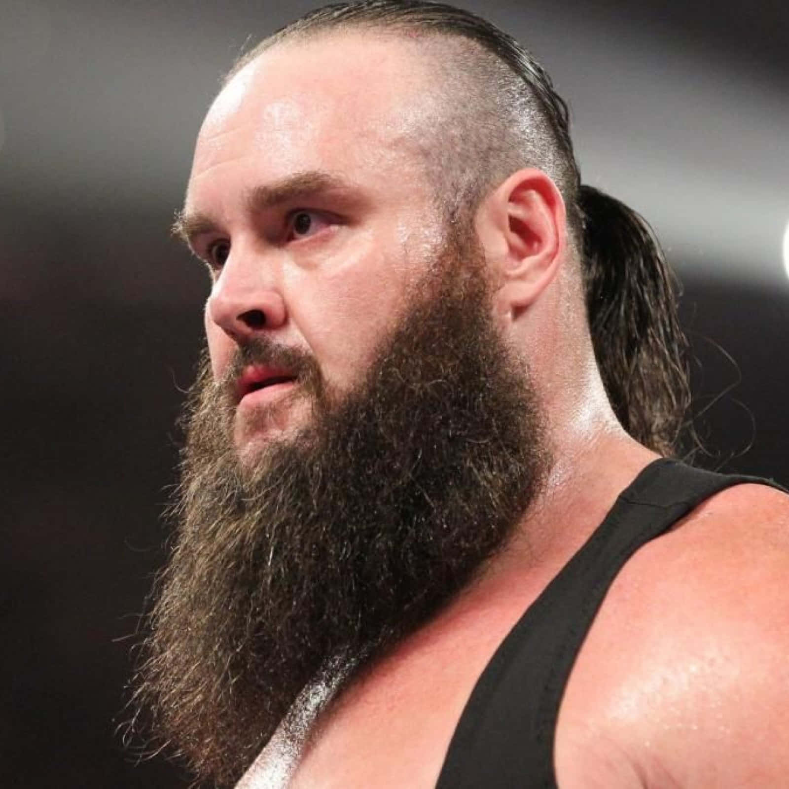 WWE 桌布 壁紙 — 一位留著長鬍鬚、頭髮向後梳、眼神銳利的摔角手穿著黑色背心的特寫。