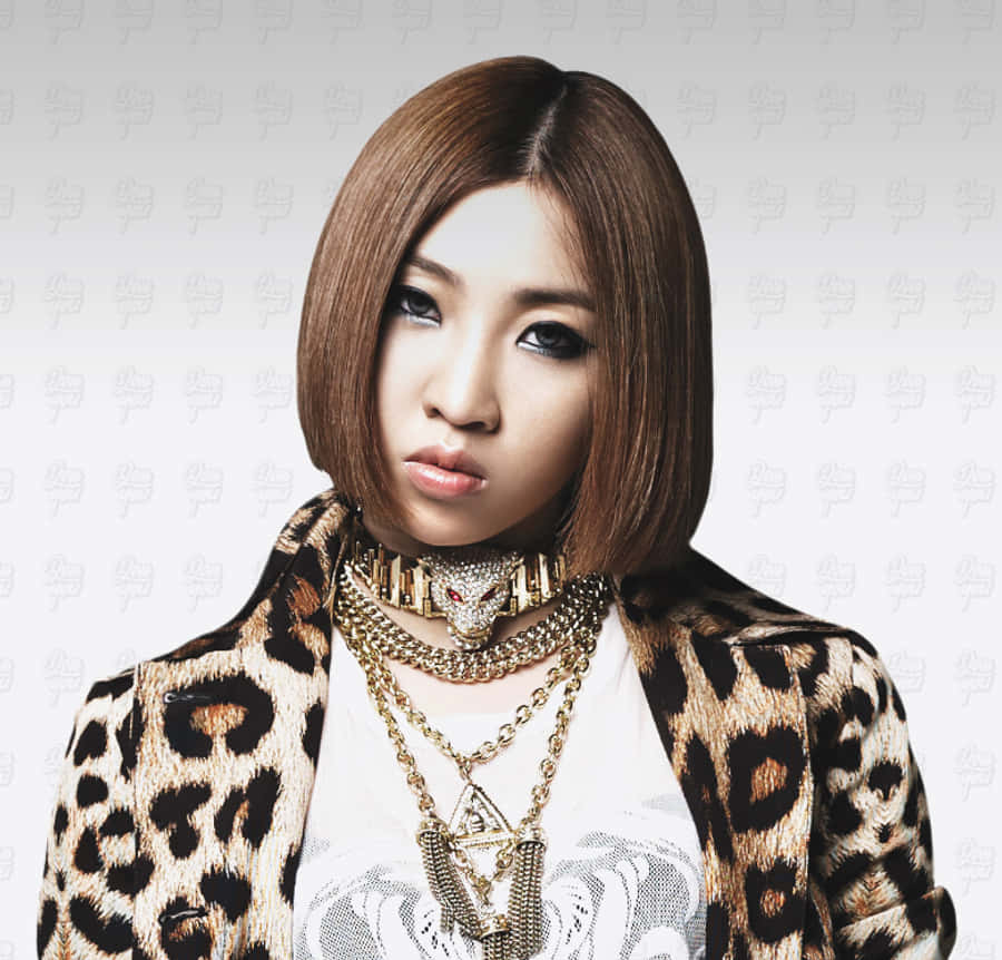 2NE1 桌布 壁紙 — 一位留著鮑伯頭的女士，穿著豹紋外套和層疊的金鍊，背景是帶有圖案的灰色。