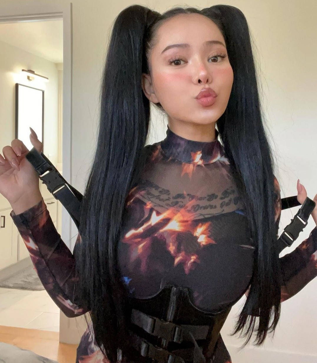 Bella Poarch 桌布 壁紙 — 一位留著黑色長辮子的女性，穿著帶有黑色背帶的火焰圖案服裝，在室內擺姿勢。