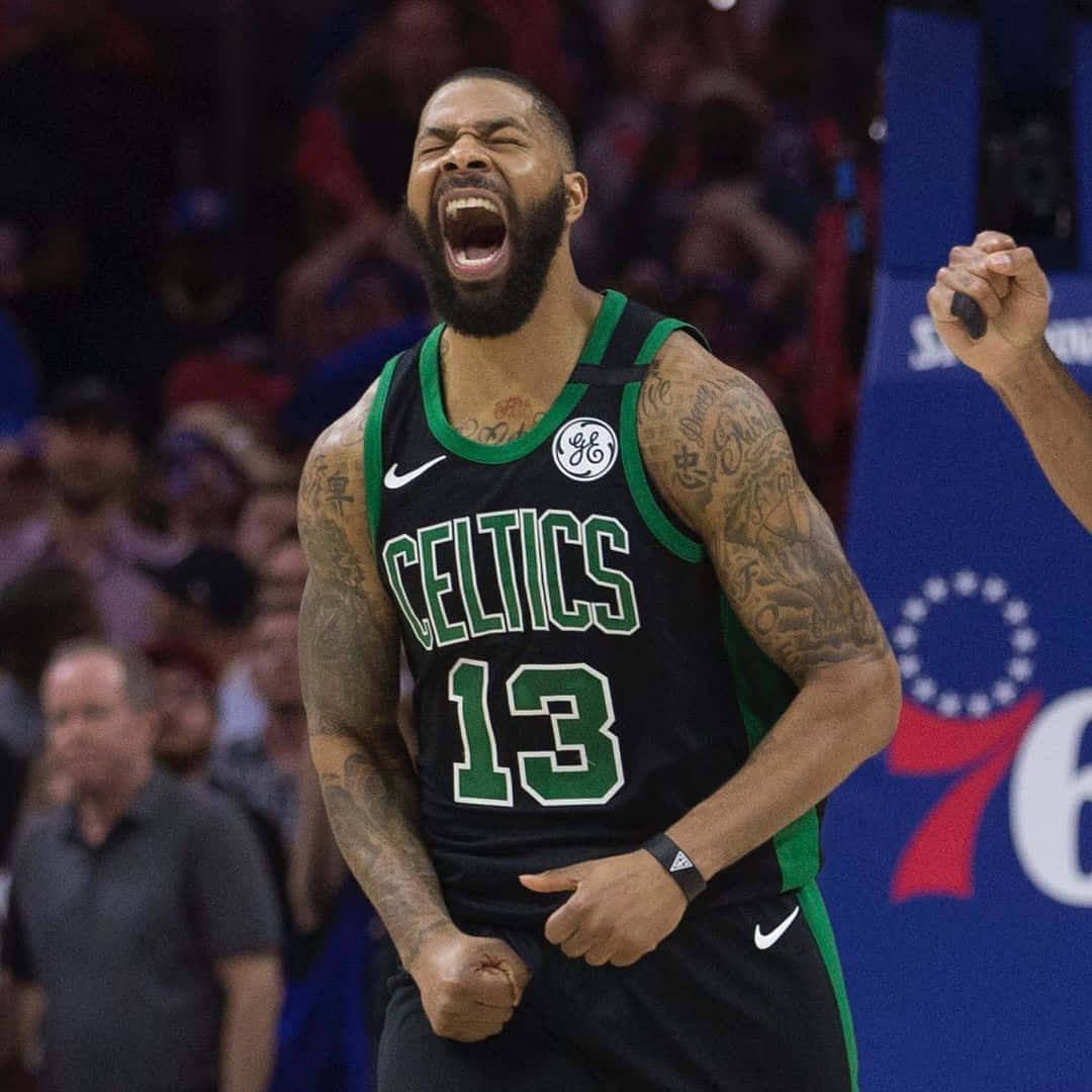 NBA 桌布 壁紙 — 一位留鬍子、有刺青的波士頓塞爾提克籃球球員在比賽中握緊拳頭，發出勝利的怒吼。