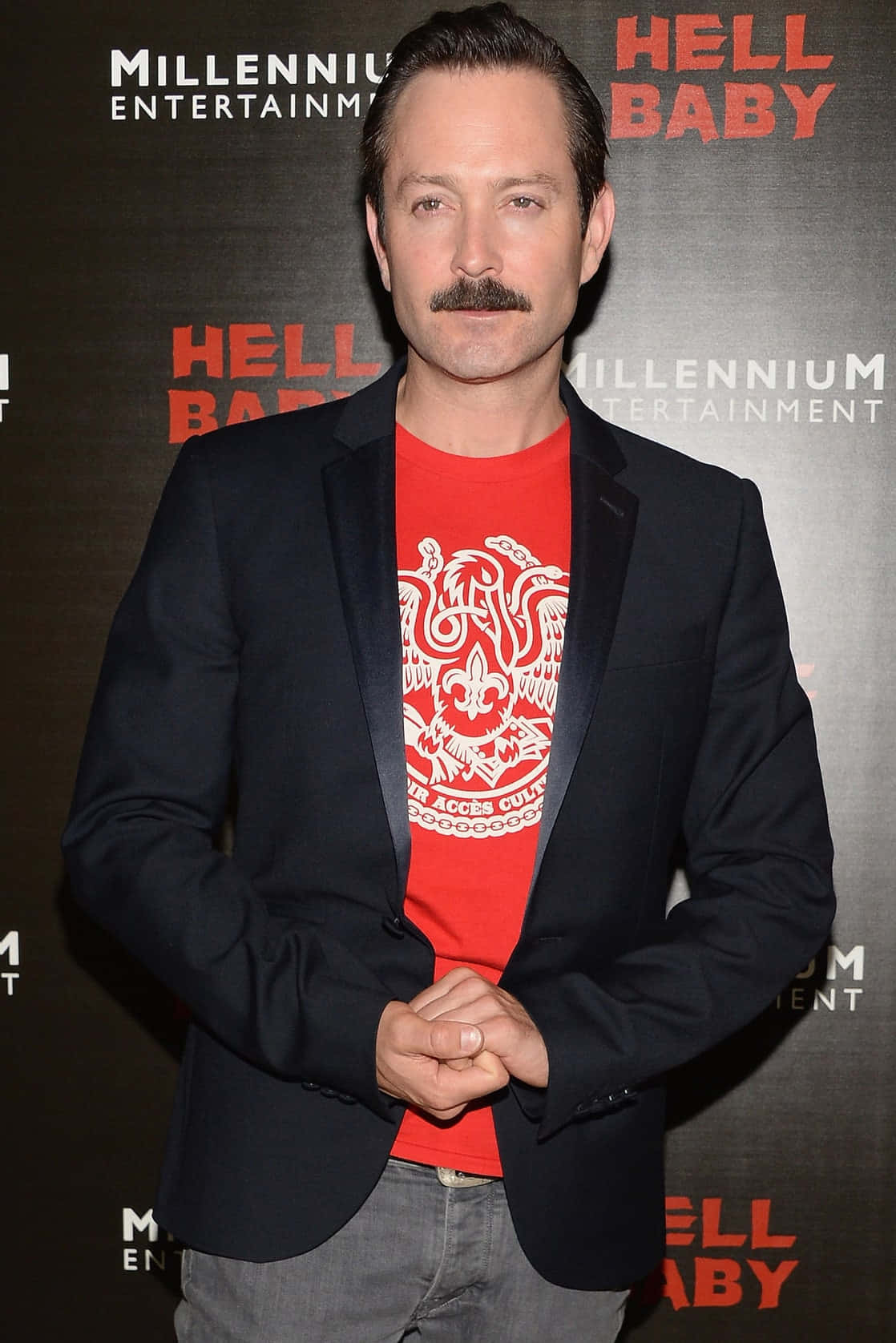 thomas lennon 桌布 壁紙 — 一位留鬍子的男士在《Hell Baby》電影首映會上，黑色西裝外套內穿紅色圖案T恤。