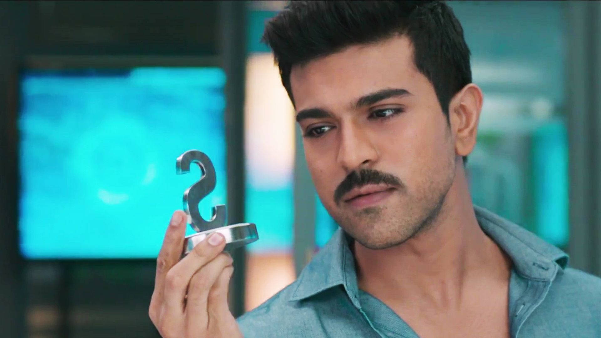 Ram Charan 桌布 壁紙 — 一位留鬍子的男士在一個現代化、帶有藍色照明的房間裡，手持一個銀色的第二名獎盃。
