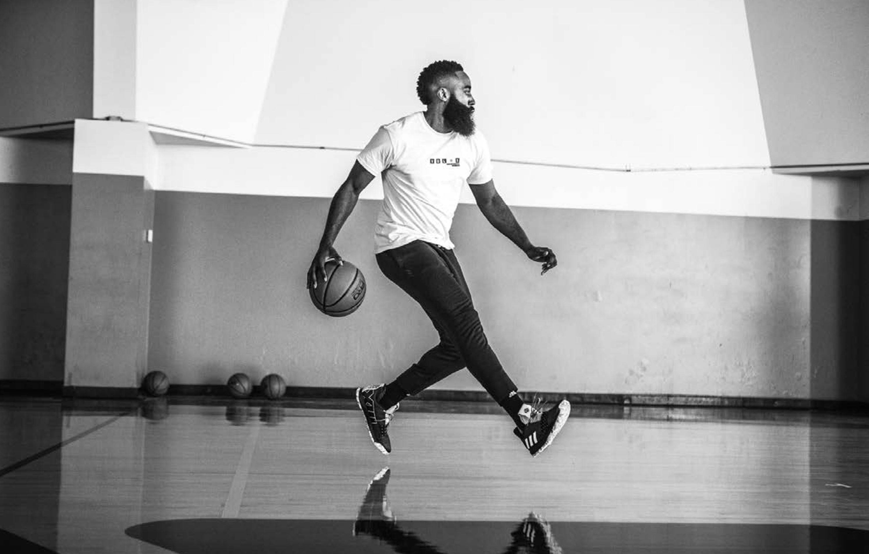 James Harden 桌布 壁紙 — 一位留鬍子的籃球運動員在黑白健身房中跳起，手持籃球，地板有反射效果。