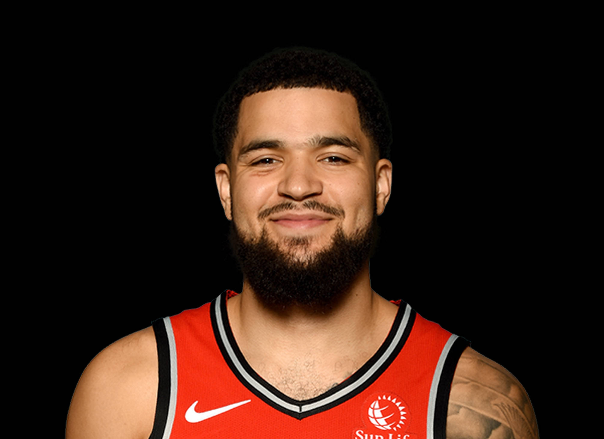 Fred Vanvleet 桌布 壁紙 — 一位留鬍子的籃球運動員微笑著，身穿紅色多倫多暴龍隊球衣，在黑色背景前擺姿勢。
