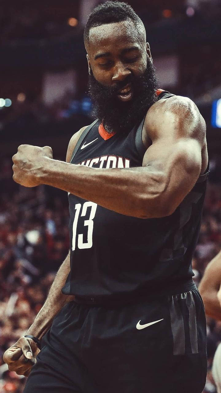 James Harden 桌布 壁紙 — 一位留鬍子的籃球運動員穿著黑色休士頓球衣，在明亮的場館燈光下比賽時緊握拳頭，神情專注。