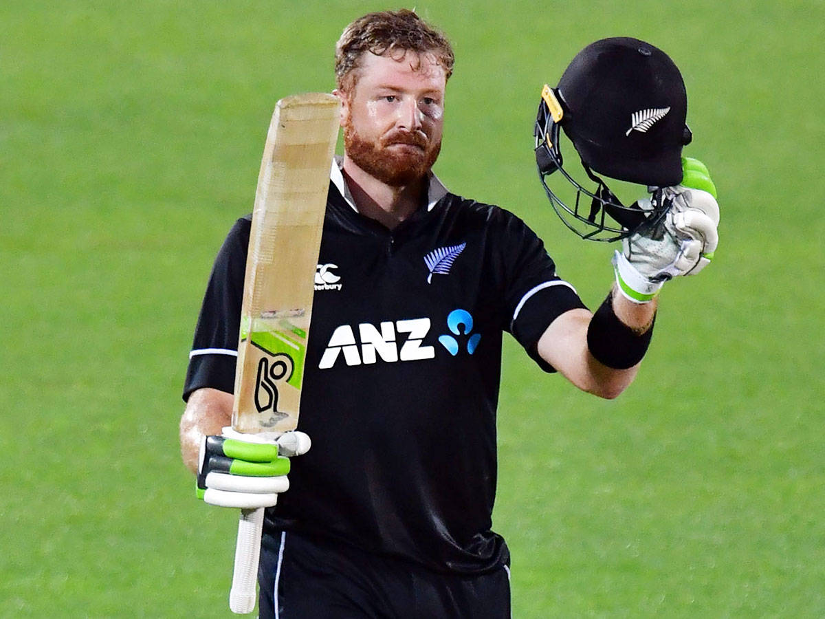 martin guptill 桌布 壁紙 — 一位留鬍子的紐西蘭板球運動員在體育場燈光下的綠色場地上手持球棒和頭盔。