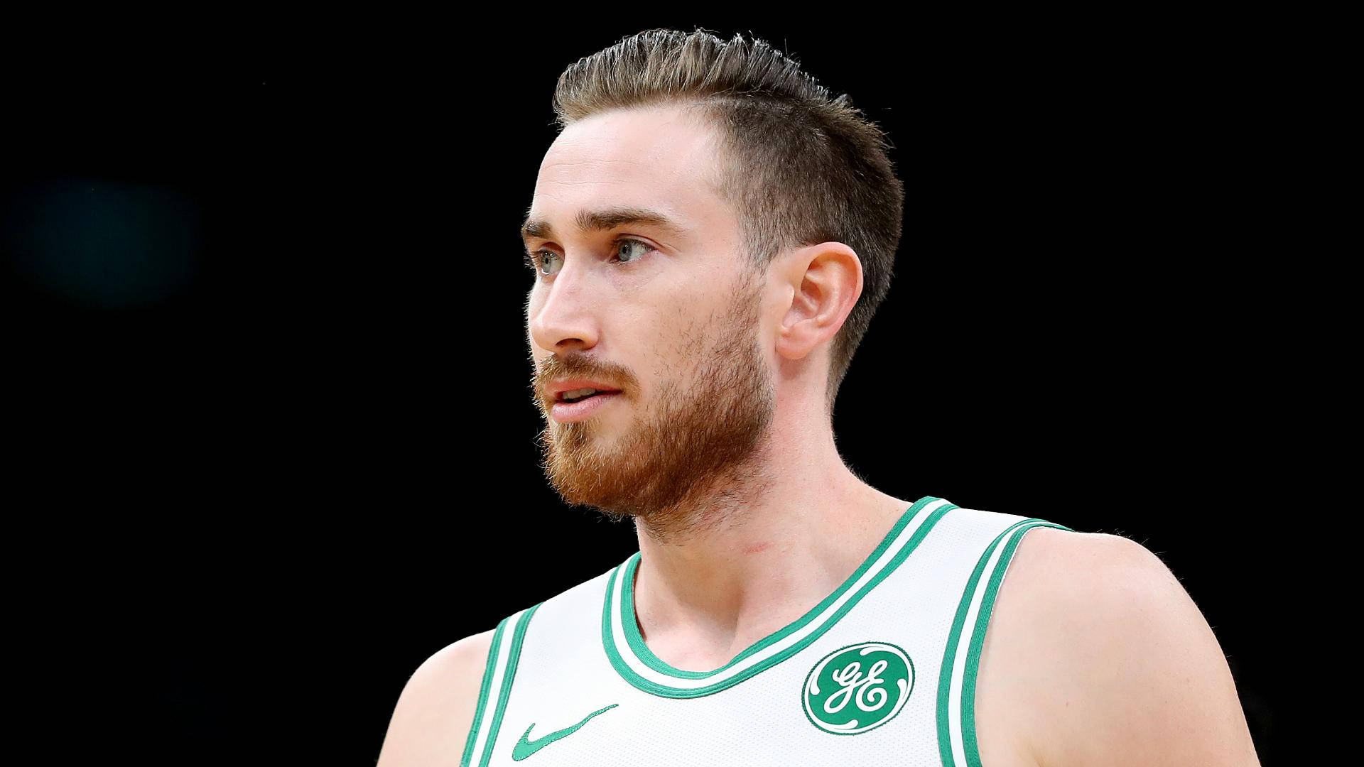 gordon hayward 桌布 壁紙 — 一位留鬍鬚、專注的籃球運動員，身穿白色和綠色球衣，背景為黑色。