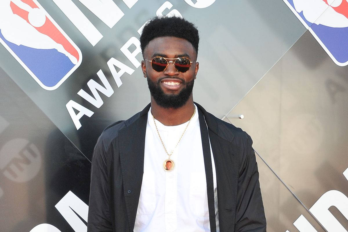 Jaylen Brown 桌布 壁紙 — 一位留鬍鬚、戴太陽眼鏡、面帶微笑的男子，身穿黑色外套和金色吊墜，在NBA Awards活動中自信地擺姿勢。
