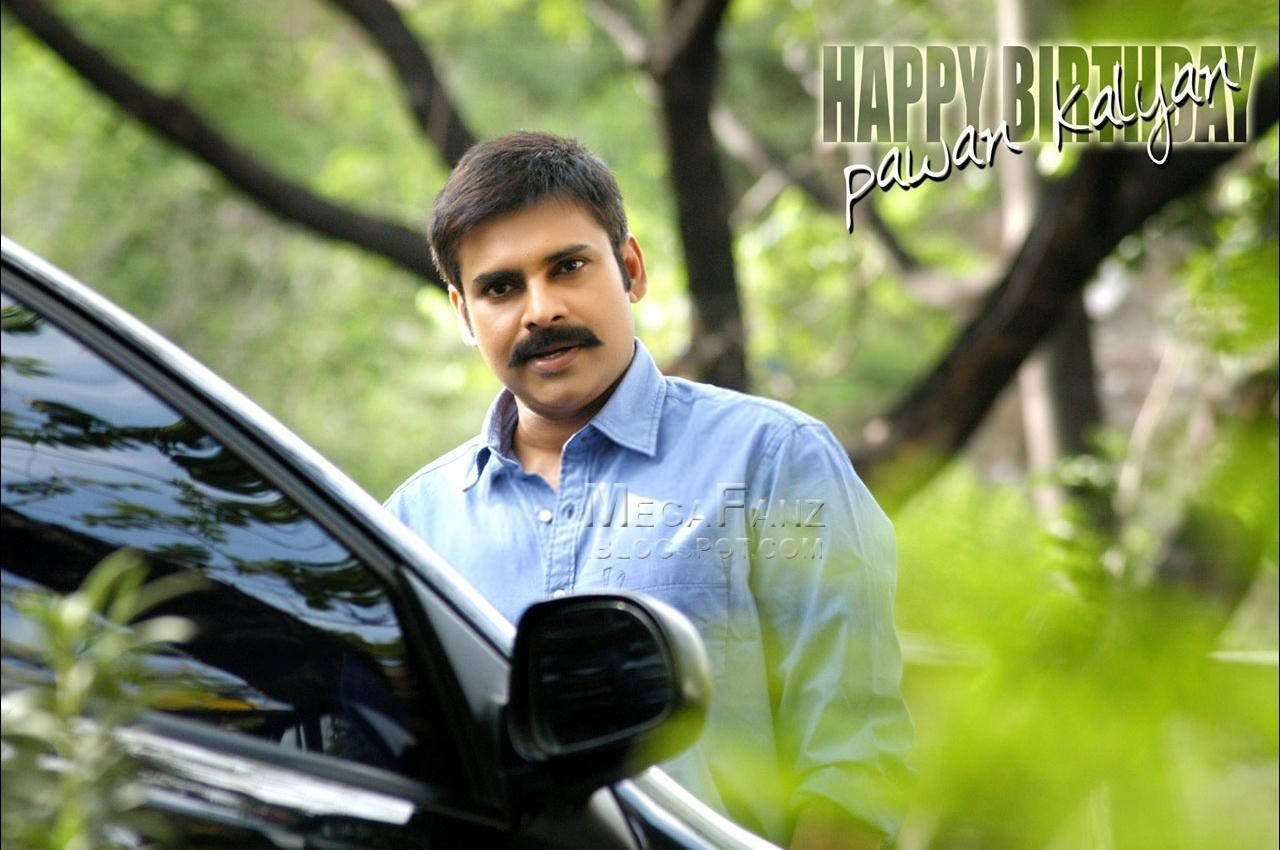 Pawan Kalyan 桌布 壁紙 — 一位留鬍鬚、穿藍色襯衫的男子站在黑色汽車旁，綠樹下覆蓋著生日文字。