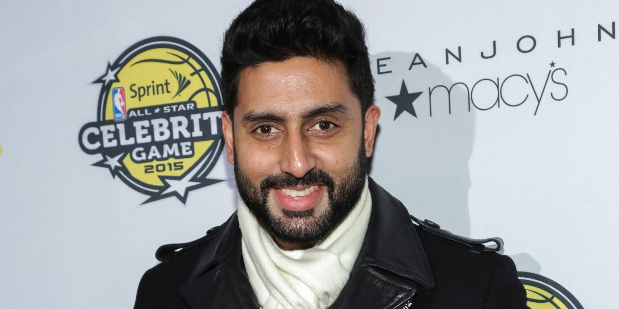abhishek bachchan 桌布 壁紙 — 一位留鬍鬚的微笑男士在2015年NBA全明星名人賽活動中穿著黑色外套和白色圍巾。