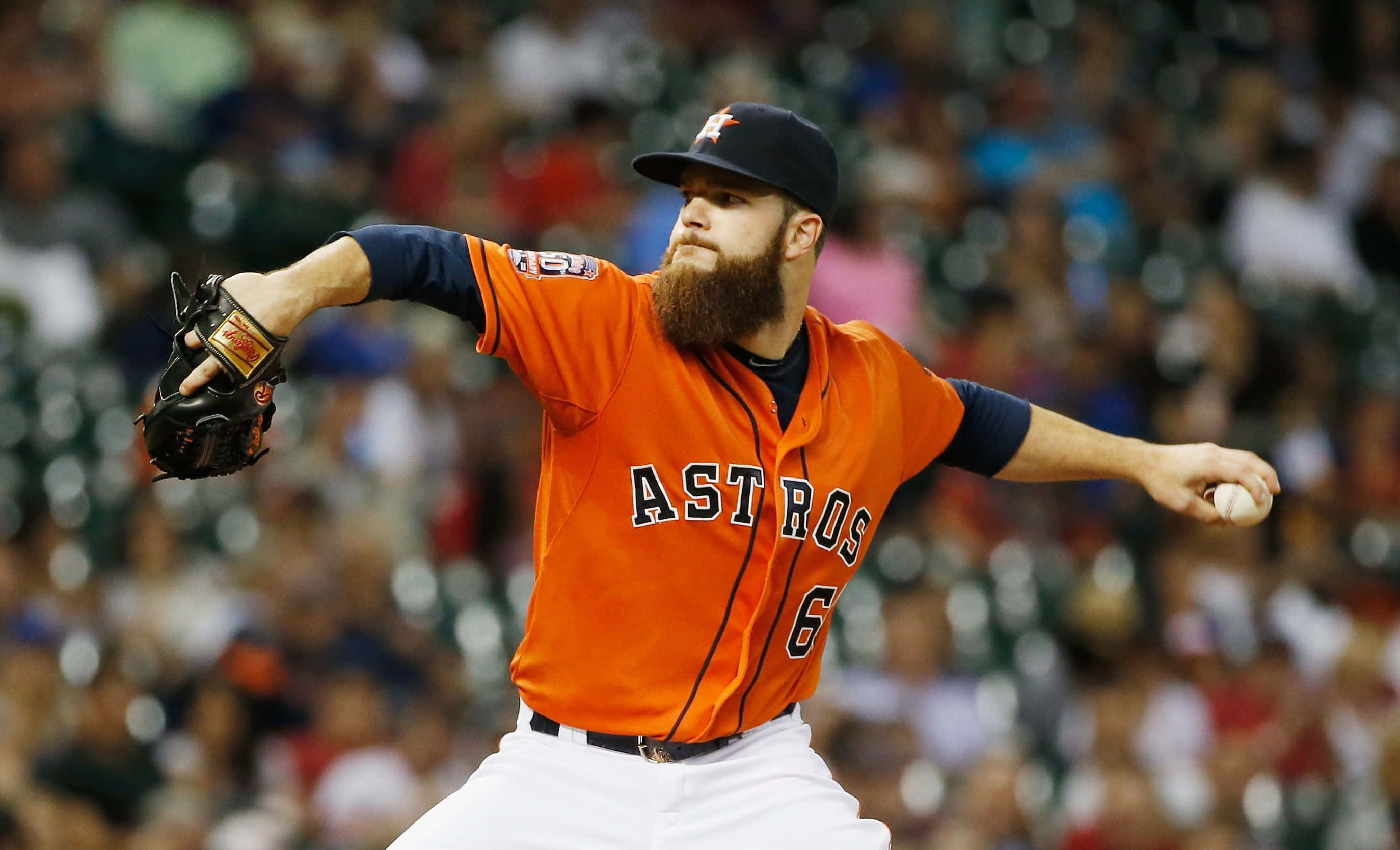Astros 桌布 壁紙 — 一位留鬍鬚的棒球投手身穿橙色太空人球衣正在投球，身後是模糊的球場人群。