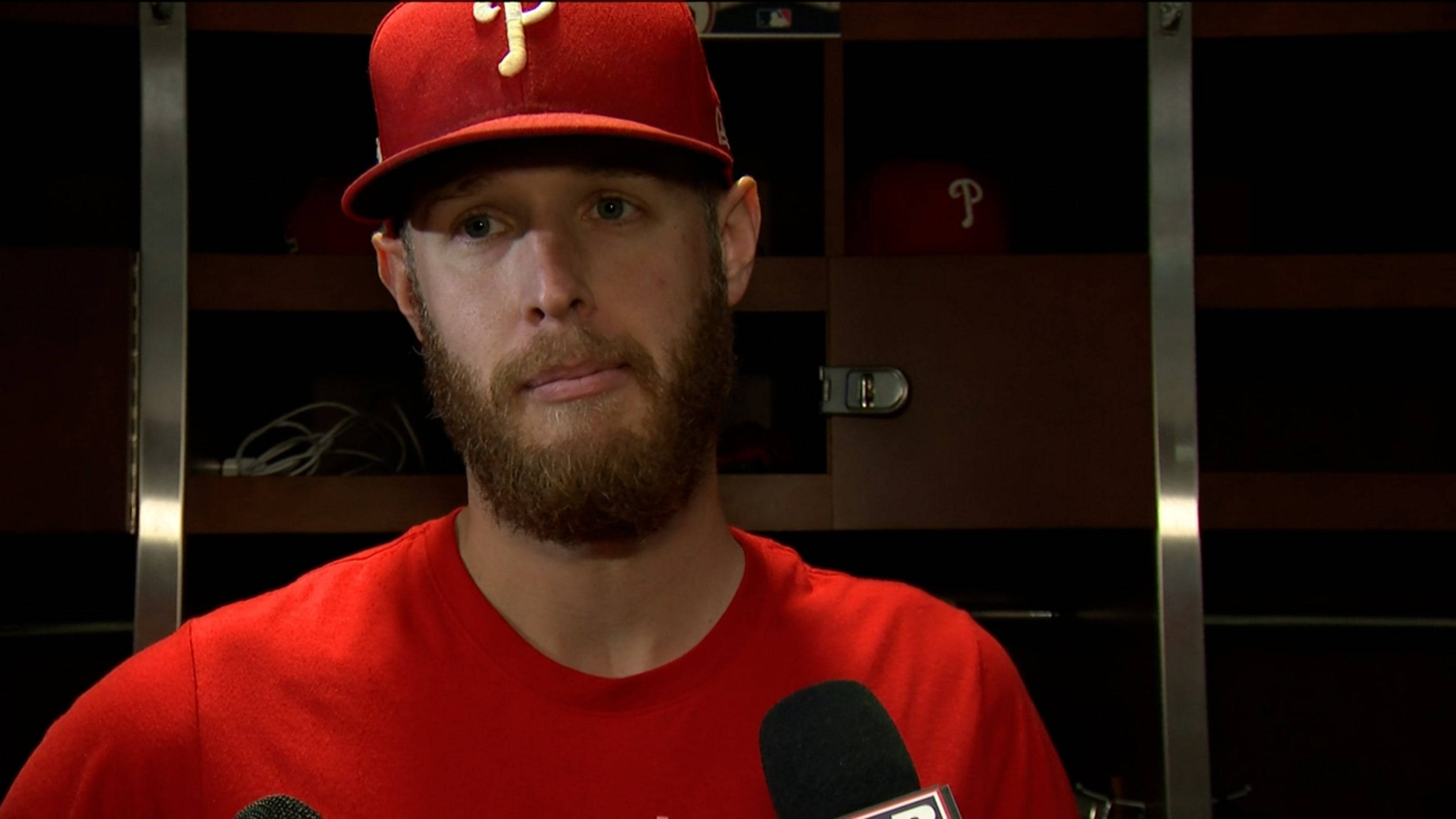 Phillies 桌布 壁紙 — 一位留鬍鬚的棒球運動員，戴著紅色帽子和穿著紅色襯衫，在燈光昏暗的更衣室裡對著麥克風說話。