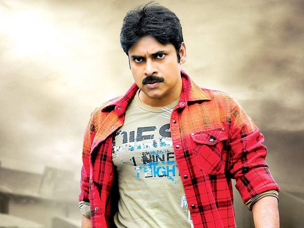 Pawan Kalyan 桌布 壁紙 — 一位留鬍鬚的男人，在模糊背景前，在圖案T恤外面穿了一件紅色格紋襯衫。