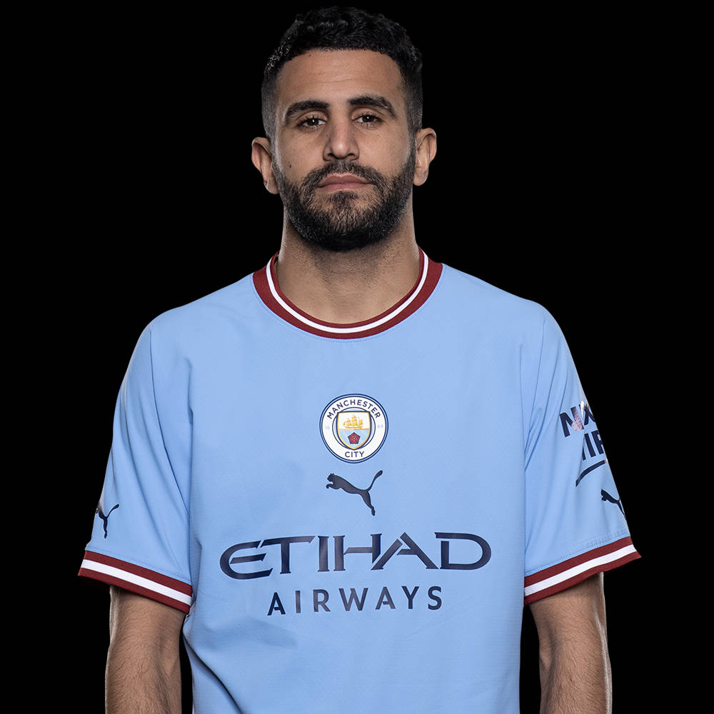 Football Players 桌布 壁紙 — 一位留鬍鬚的男人在黑色背景前穿著淺藍色曼徹斯特城足球球衣。