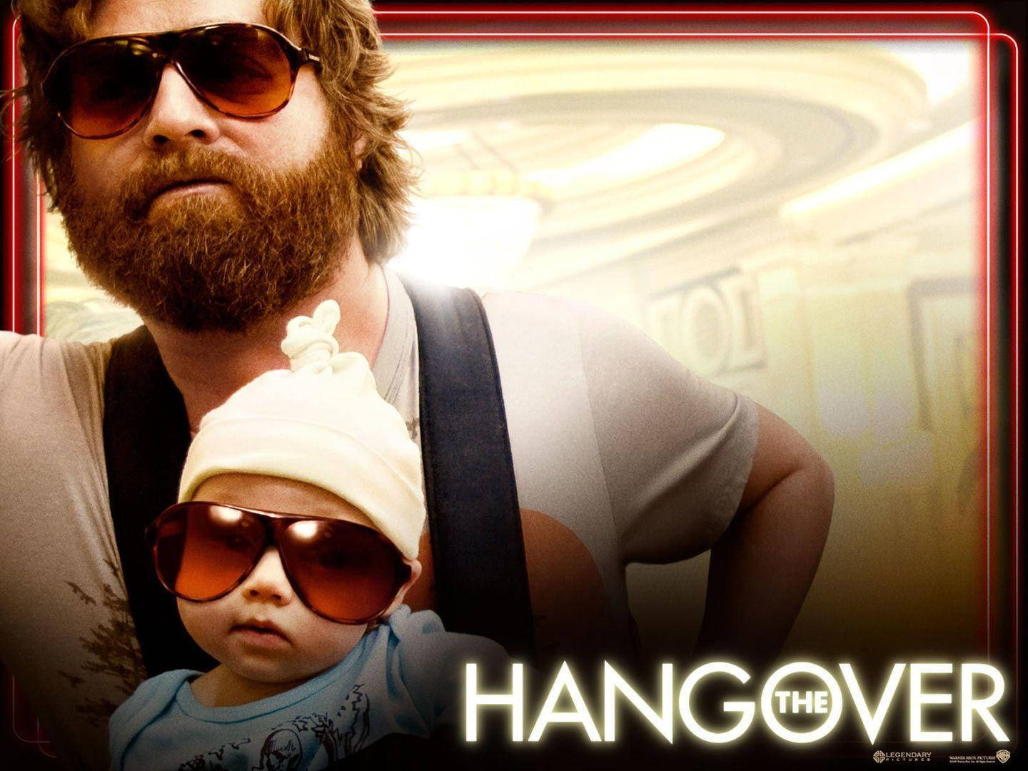 the hangover 桌布 壁紙 — 一位留鬍鬚的男人戴著太陽眼鏡，在模糊的飯店走廊背景下抱著一個戴著超大太陽眼鏡和白色帽子的嬰兒。