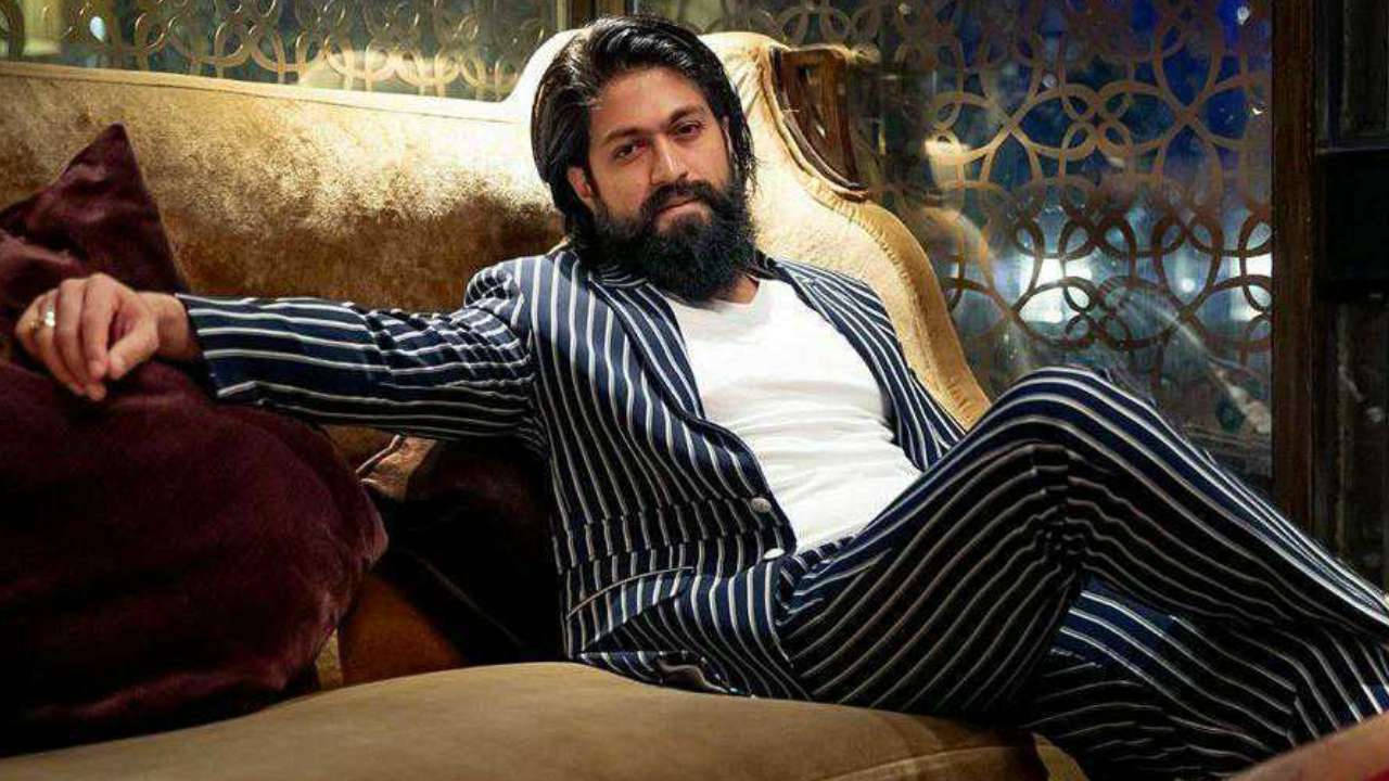 Indian 桌布 壁紙 — 一位留鬍鬚的男人穿著藍色條紋西裝，自信地躺在一張豪華的金色椅子上，房間裝飾華麗。