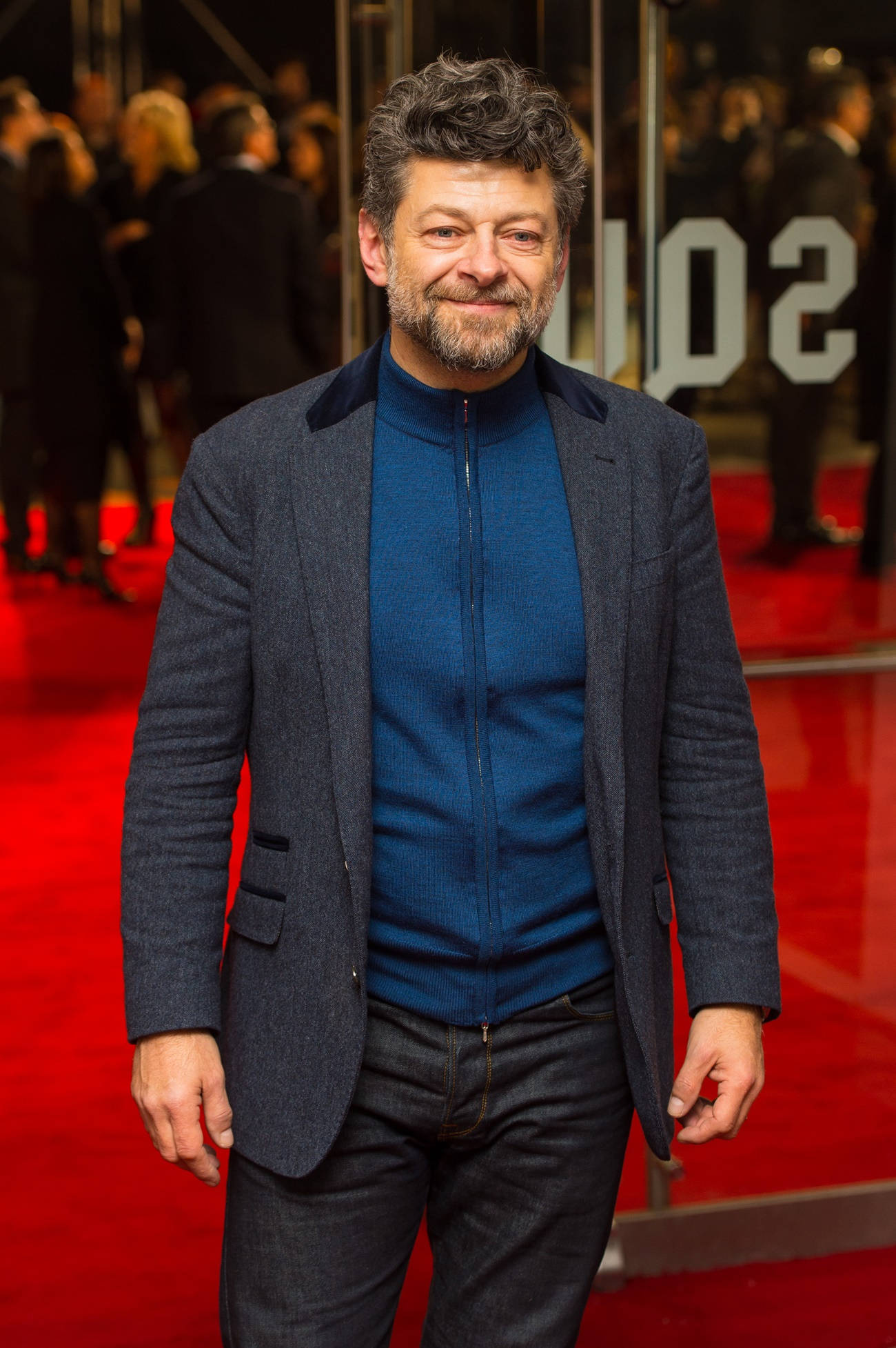 actor 桌布 壁紙 — 一位留鬍鬚的男士面帶微笑，自信地站在華麗活動的鮮紅地毯上。