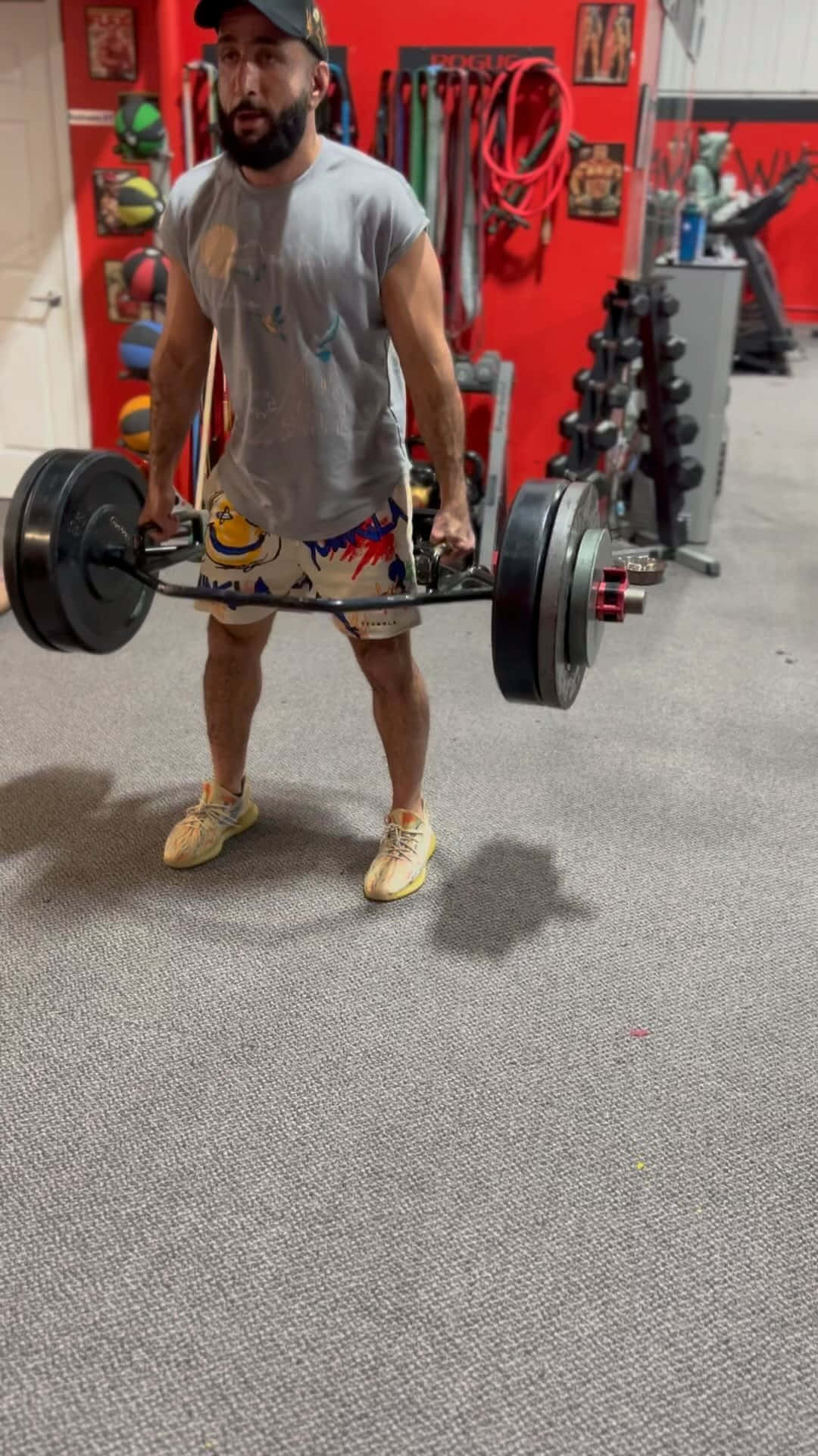 Fitness 桌布 壁紙 — 一位留鬍鬚的男子在健身房舉起帶有重物的槓鈴，穿著色彩繽紛的短褲和帽子。