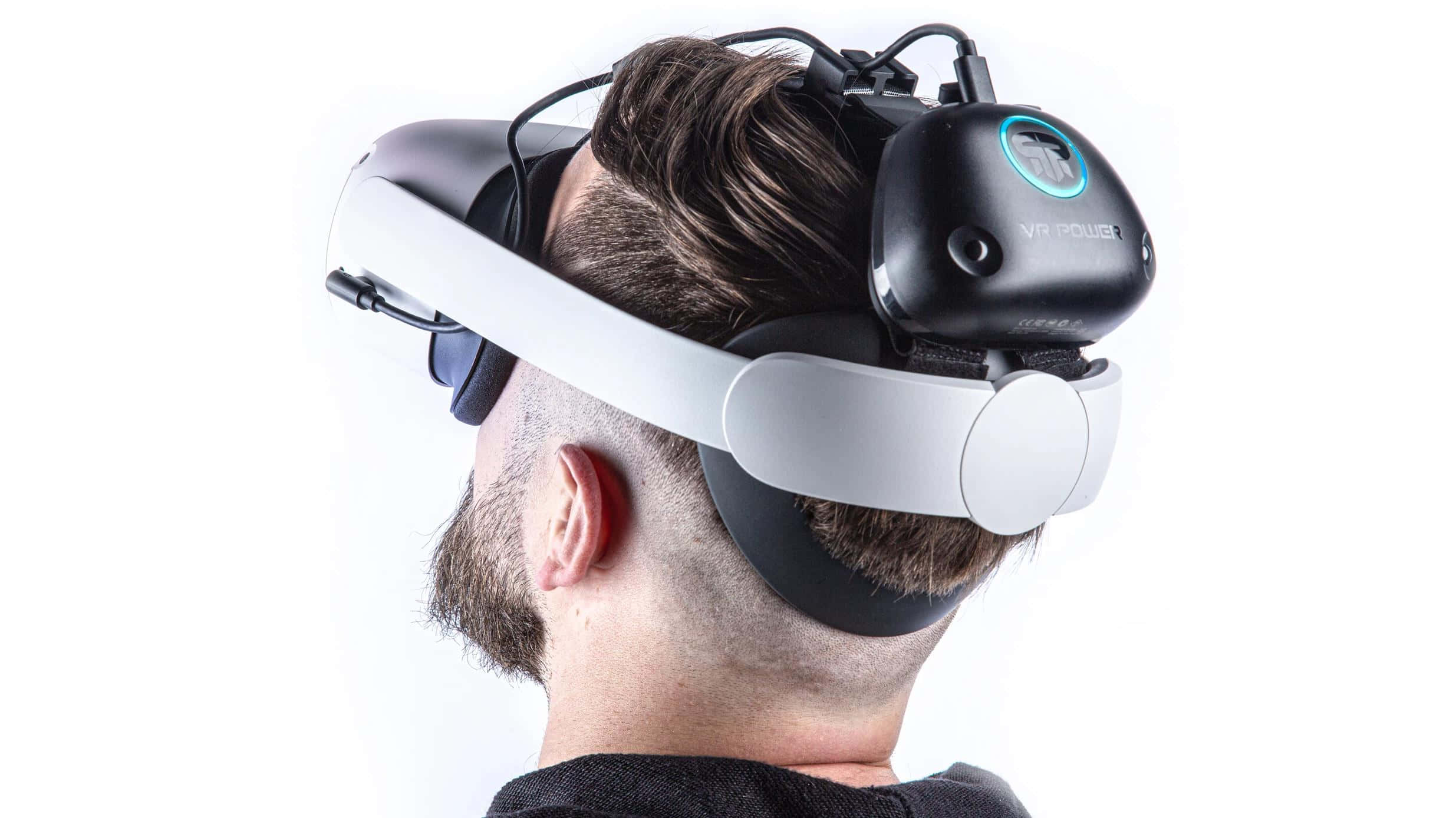 Oculus Quest 2 桌布 壁紙 — 一位留鬍鬚的男子戴著白色和黑色的VR頭戴式裝置，上面有發光的藍色標誌，背景是純白色。
