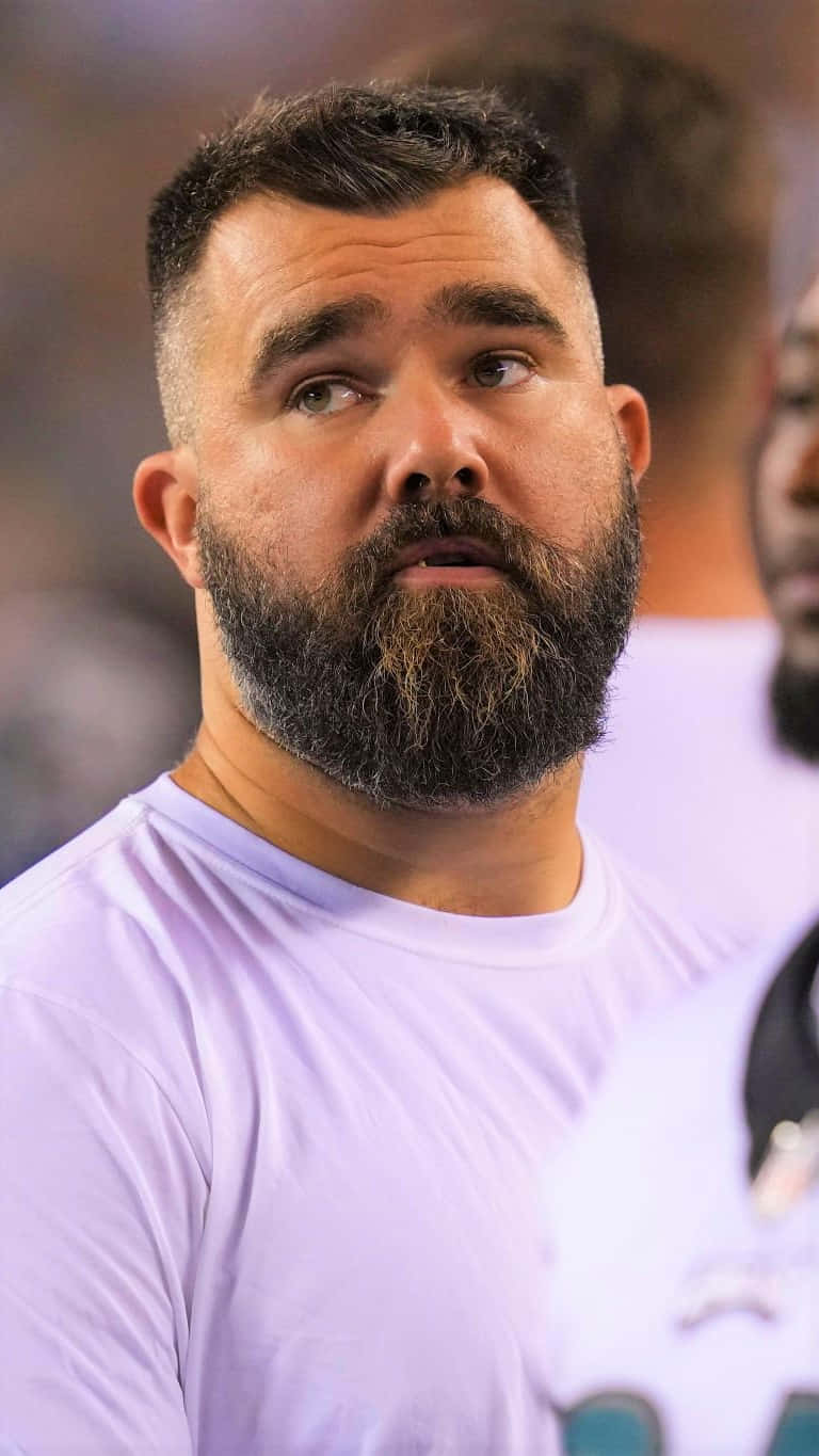 Jason Kelce 桌布 壁紙 — 一位留鬍鬚的男子身穿淺紫色T恤，專注地向上望的特寫。