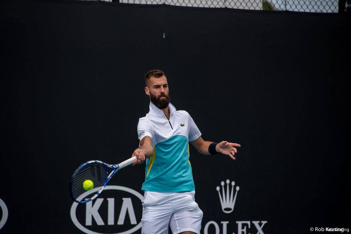 Tennis 桌布 壁紙 — 一位留鬍鬚的男性網球選手，身穿青綠色和白色襯衫，在帶有贊助商標誌的黑色牆壁前揮拍擊打黃色球。