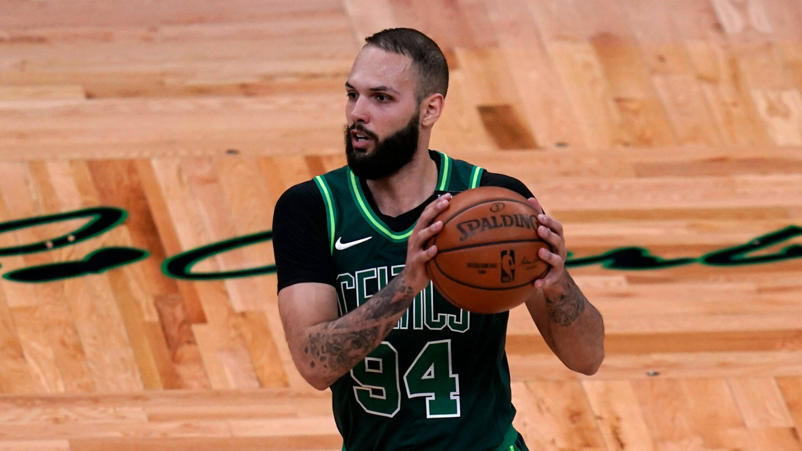 NBA 桌布 壁紙 — 一位留鬍鬚的籃球運動員身穿綠色塞爾提克球衣，在木地板上拿著一個Spalding籃球。