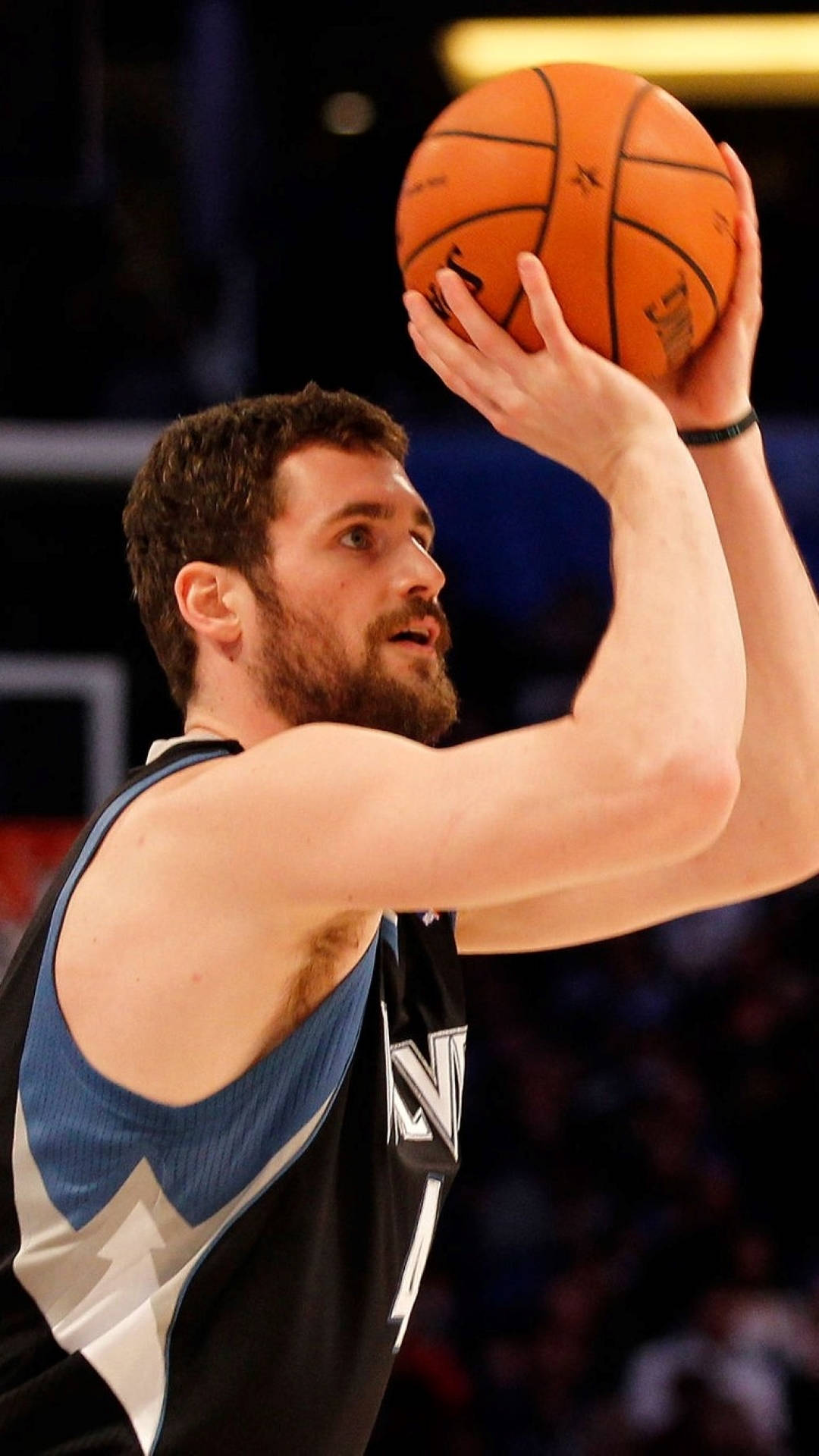 Kevin Love 桌布 壁紙 — 一位留鬍鬚的籃球運動員身穿黑藍色球衣，在場館燈光下專注地投籃。