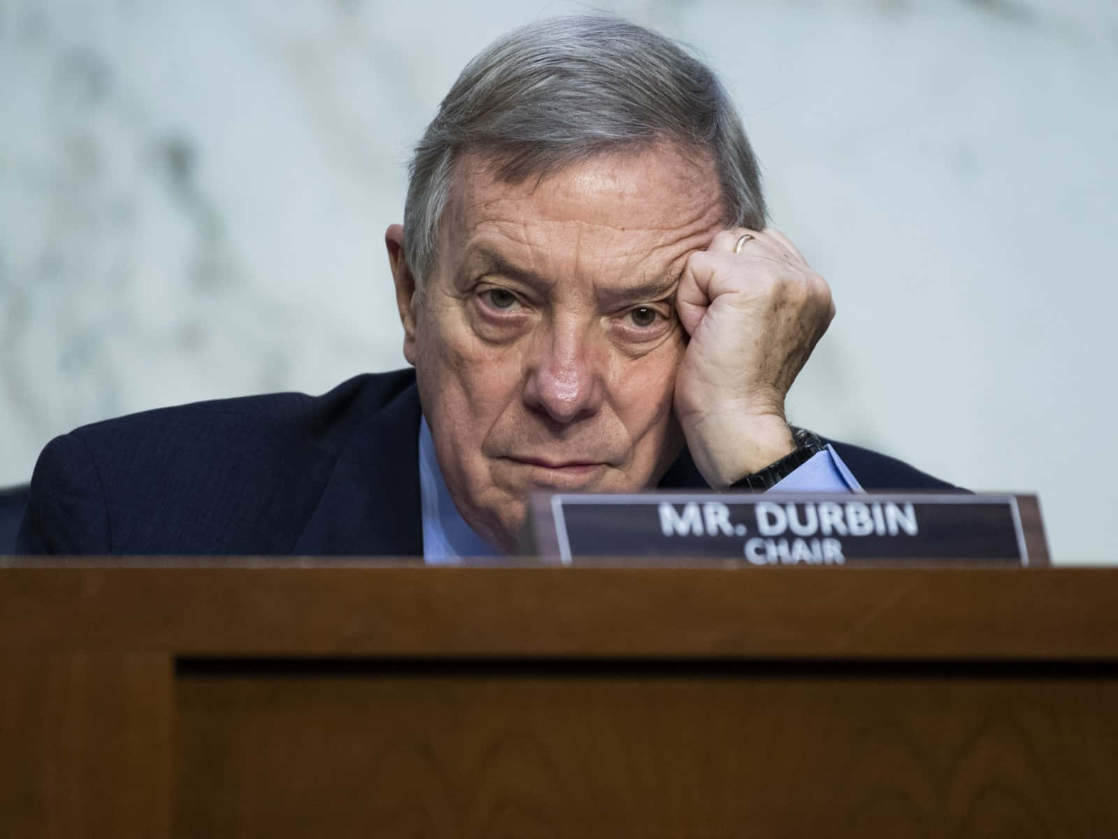 Celebrity 桌布 壁紙 — 一位疲憊的白髮男子在一個寫著 MR DURBIN CHAIR 的木桌上用手托著頭休息。