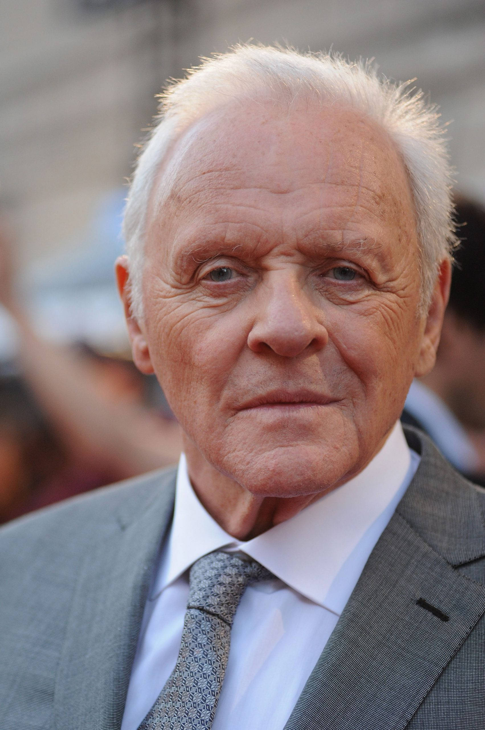 actor 桌布 壁紙 — 一位白髮、藍眼睛深邃的長者特寫肖像，身穿灰色西裝及圖案領帶。