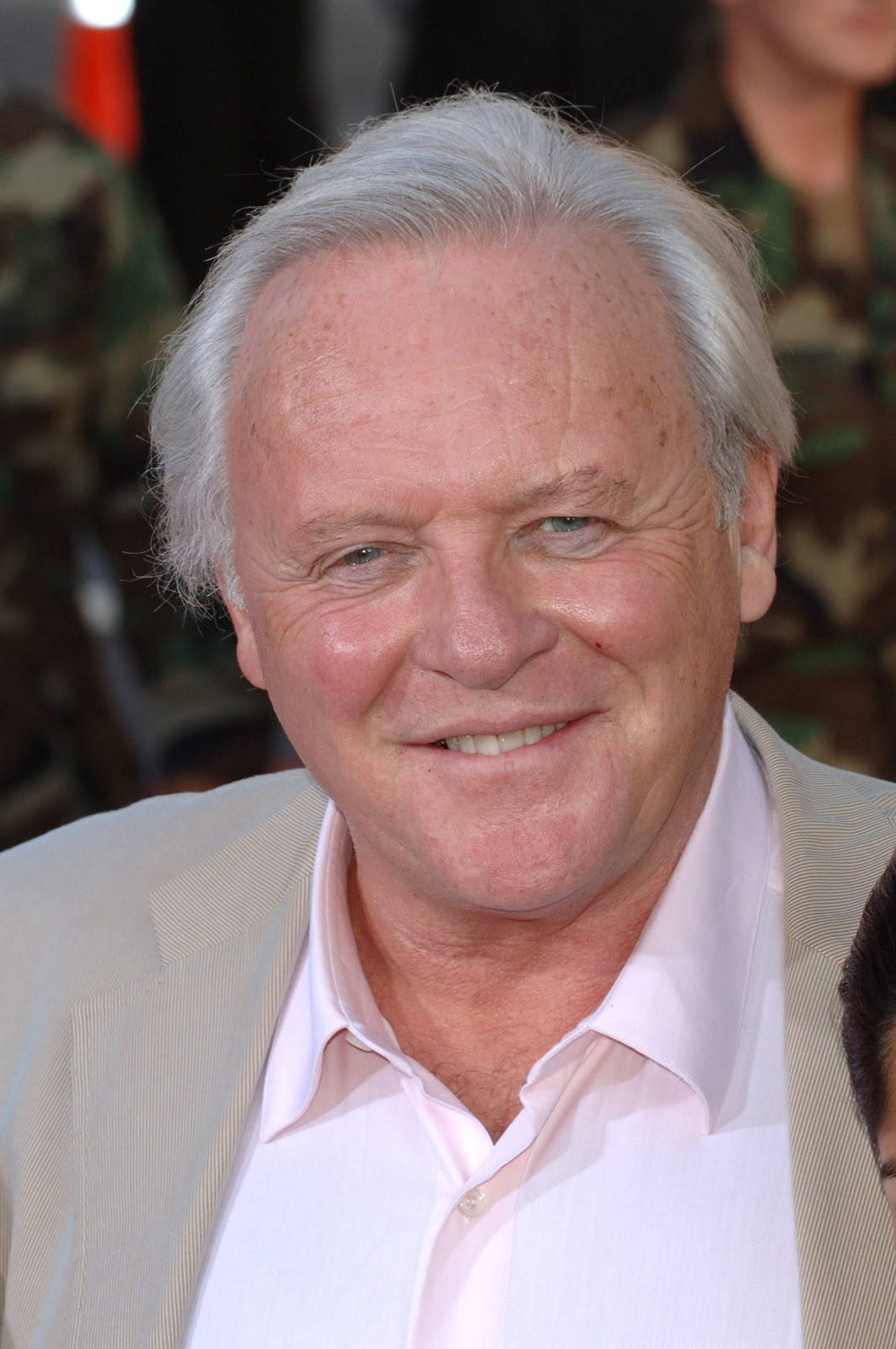 actor 桌布 壁紙 — 一位白髮微笑的老年男士穿著淺米色西裝和粉紅色襯衫的特寫肖像。