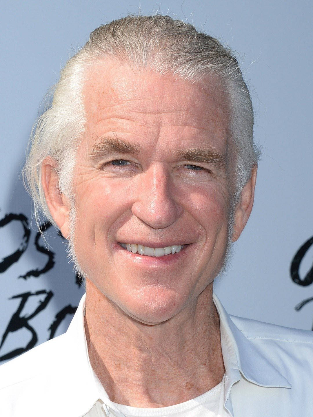 Celebrity 桌布 壁紙 — 一位白髮微笑的老年男子穿著白襯衫，以淺藍色背景為襯的特寫肖像。
