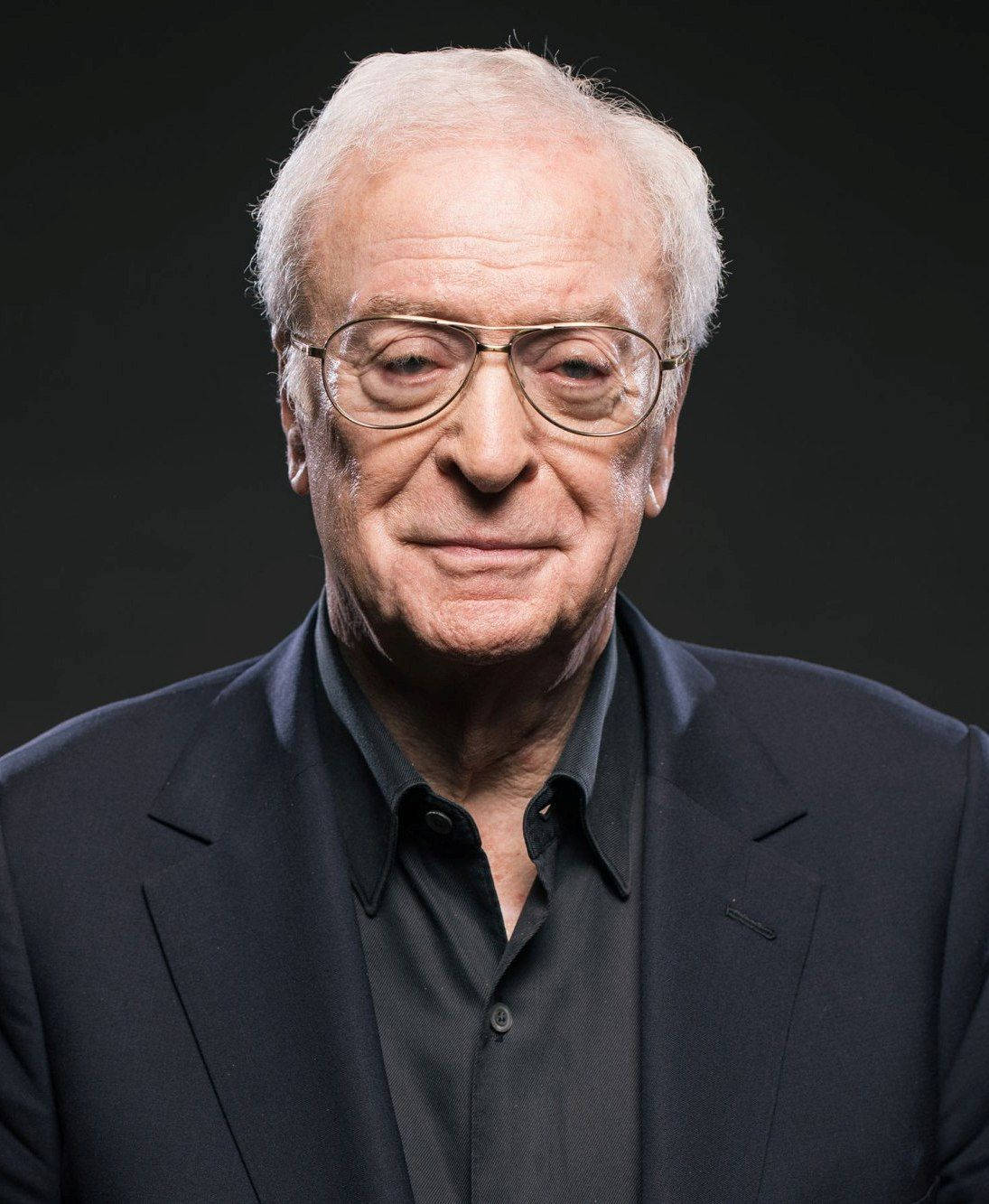 actor 桌布 壁紙 — 一位白髮戴眼鏡的老年男子穿著深色西裝在黑色背景前的特寫肖像。