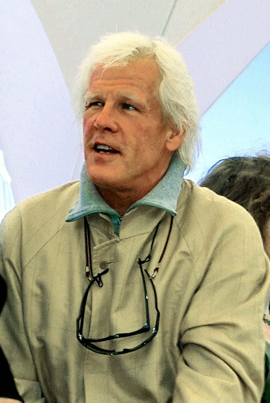 Nick Nolte 桌布 壁紙 — 一位白髮男子，眼鏡掛在米色外套上，向上看，表情投入。