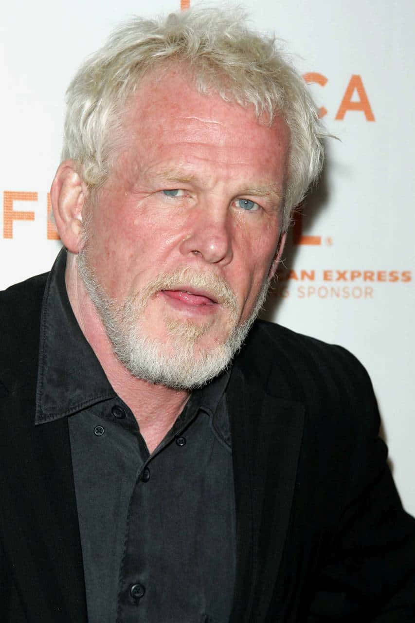 Nick Nolte 桌布 壁紙 — 一位白髮白鬍鬚男士在活動中穿著黑色西裝和襯衫的特寫肖像。