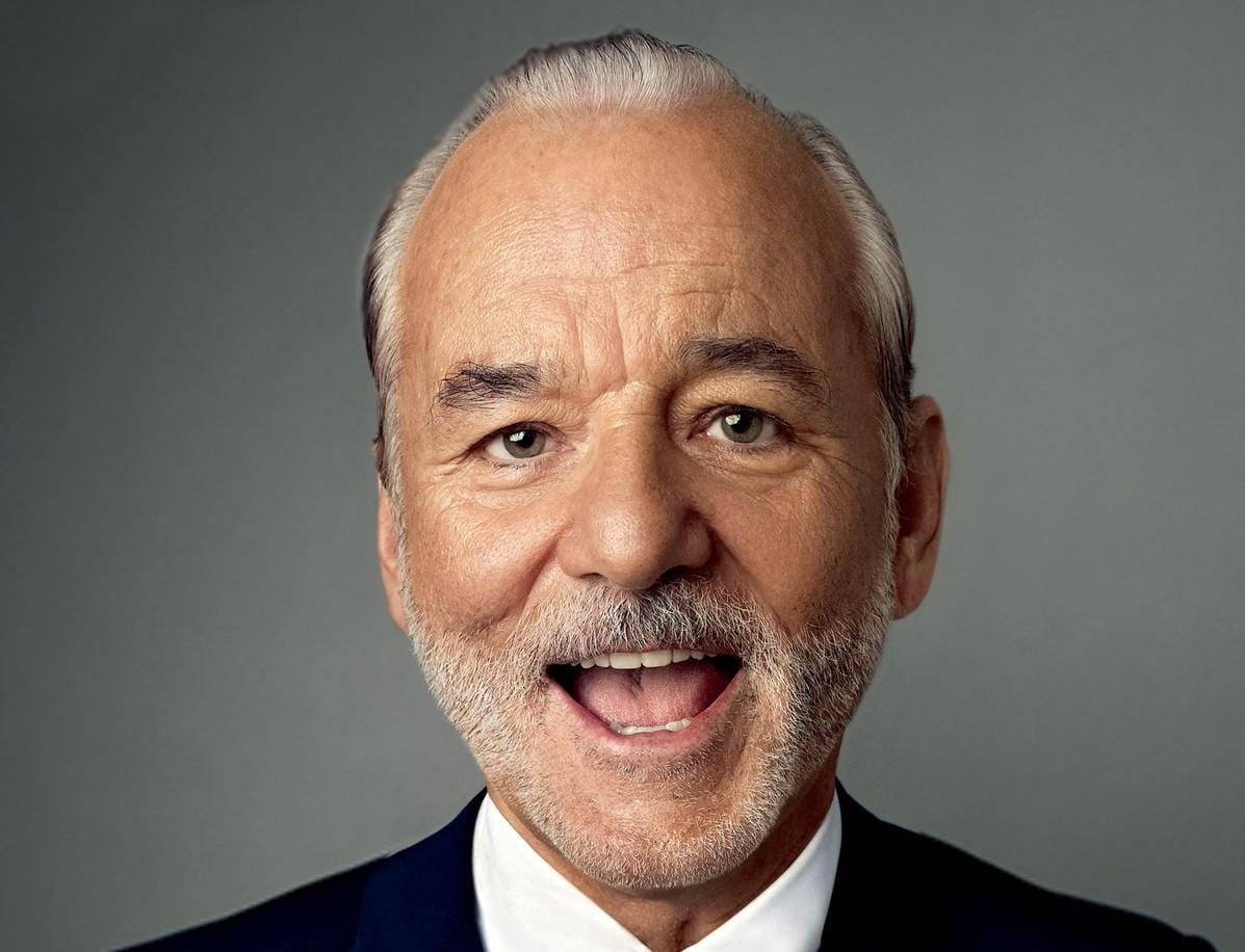 Celebrity 桌布 壁紙 — 一位白髮白鬍鬚的開朗老年男士穿著西裝，在灰色背景前的特寫肖像。