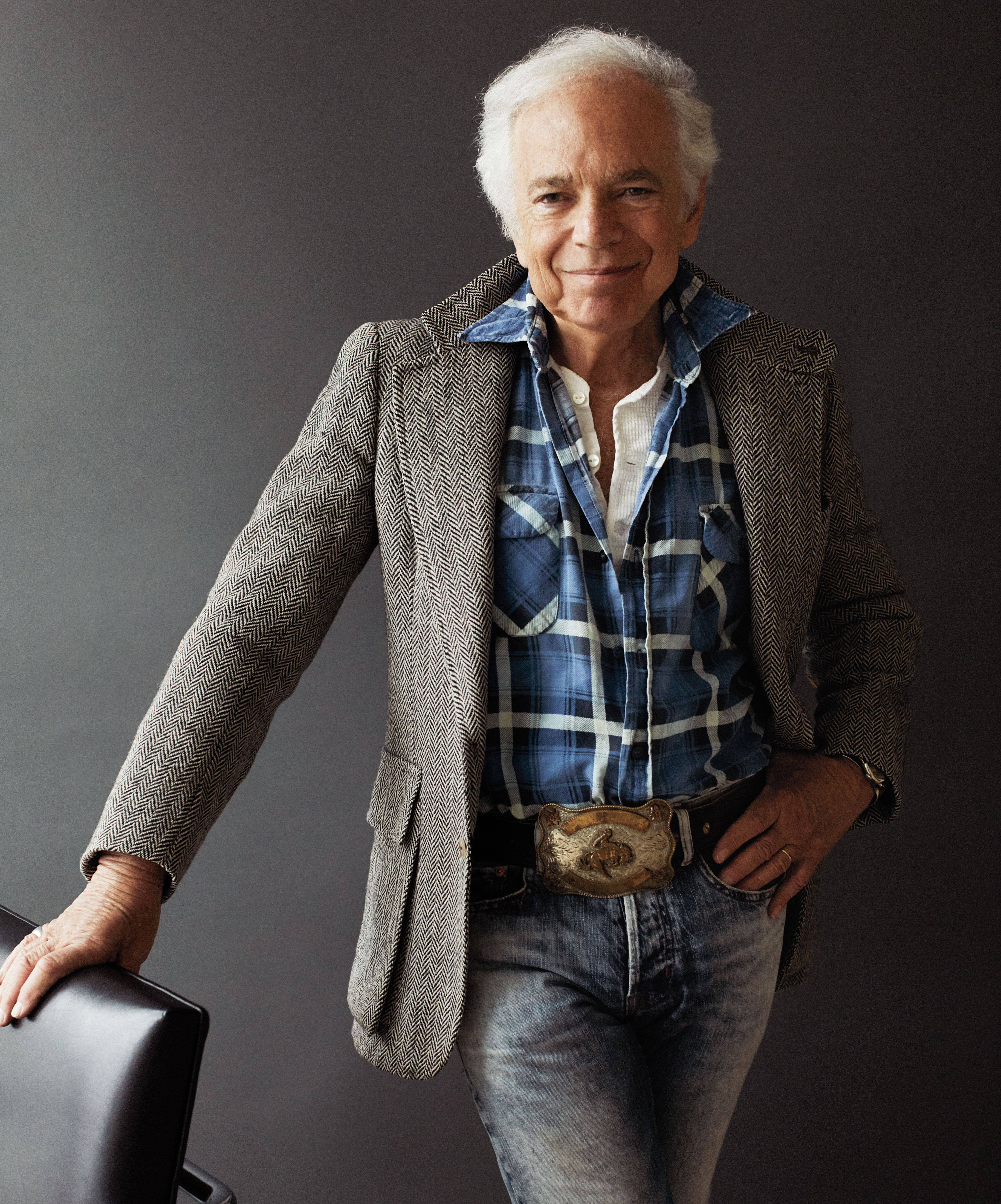 ralph lauren 桌布 壁紙 — 一位白髮的時尚年長男士微笑著靠在椅子上，穿著人字紋西裝外套和格紋襯衫。