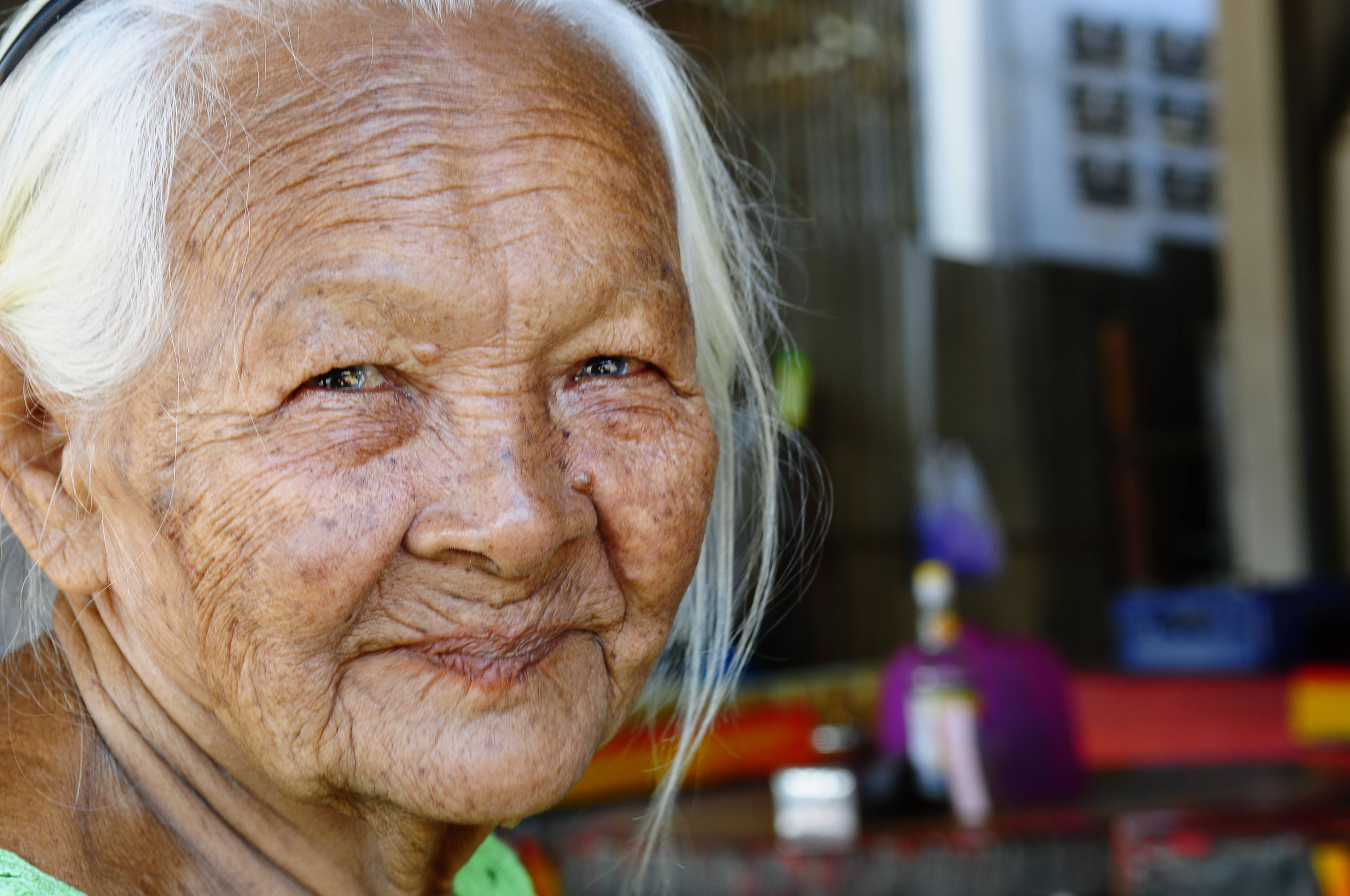 smiling 桌布 壁紙 — 一位白髮蒼蒼、滿臉皺紋的老婦人對著鏡頭溫暖微笑的特寫肖像。