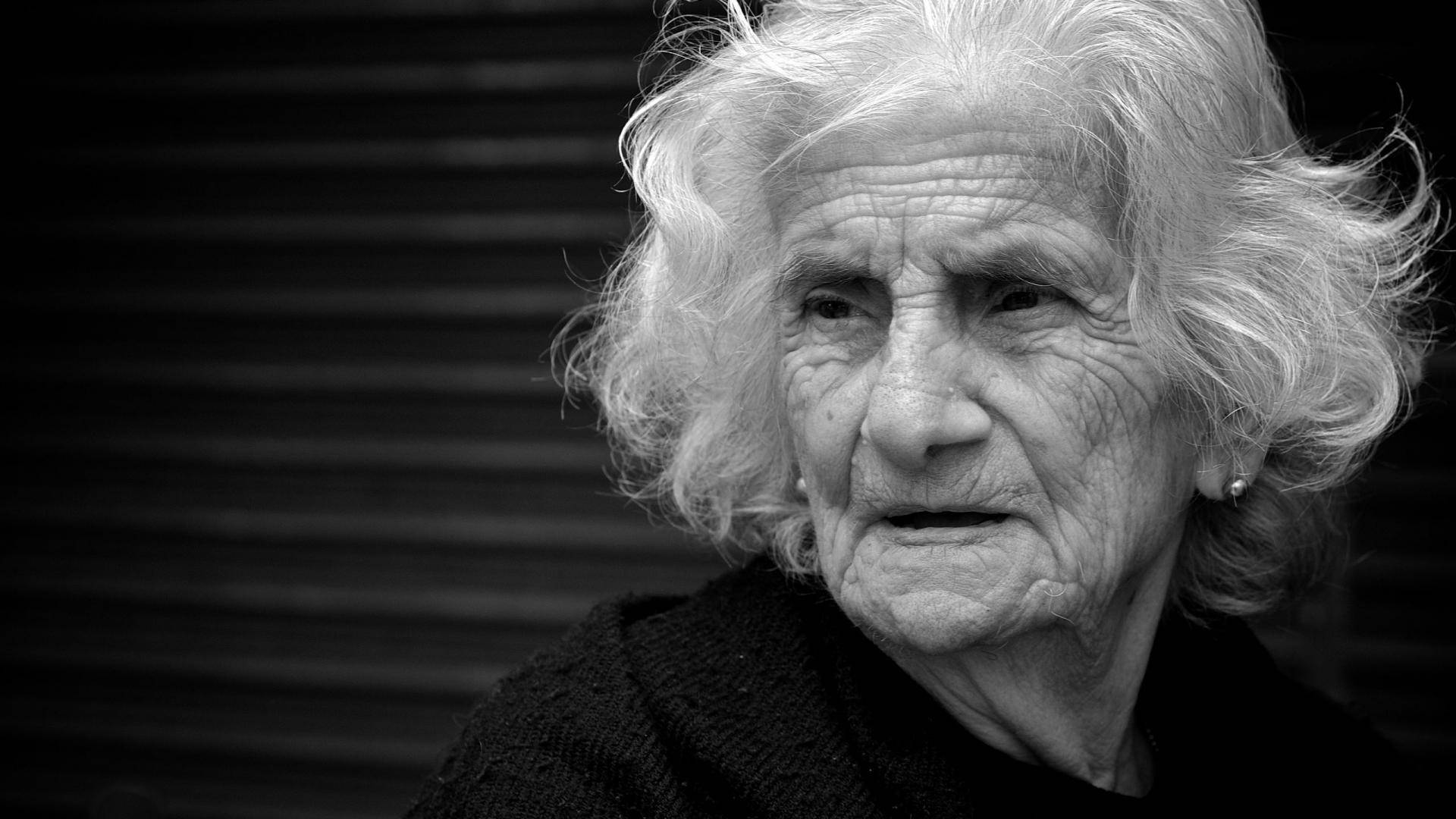 Woman 桌布 壁紙 — 一位白髮蓬鬆、滿臉皺紋的年長女士的黑白特寫肖像，在條紋背景前若有所思地凝視。