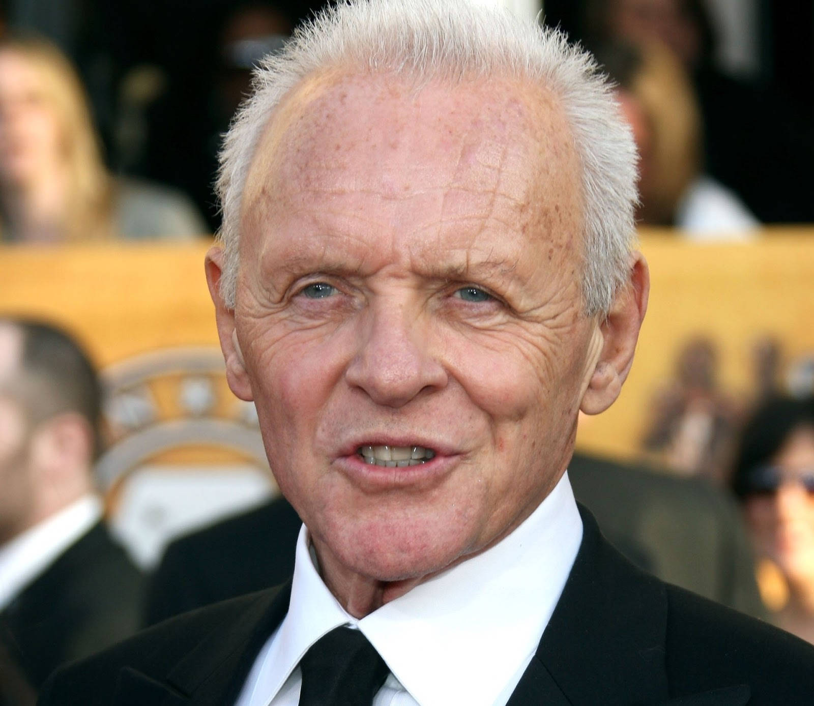 actor 桌布 壁紙 — 一位白髮藍眼的年長男士在正式活動中穿著黑色西裝和領帶的特寫肖像。